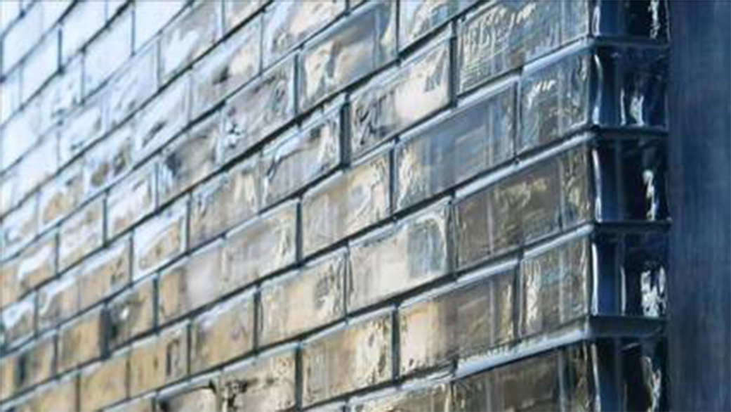 Close-up view of a brick wall with glossy bricks and dark mortar joints.