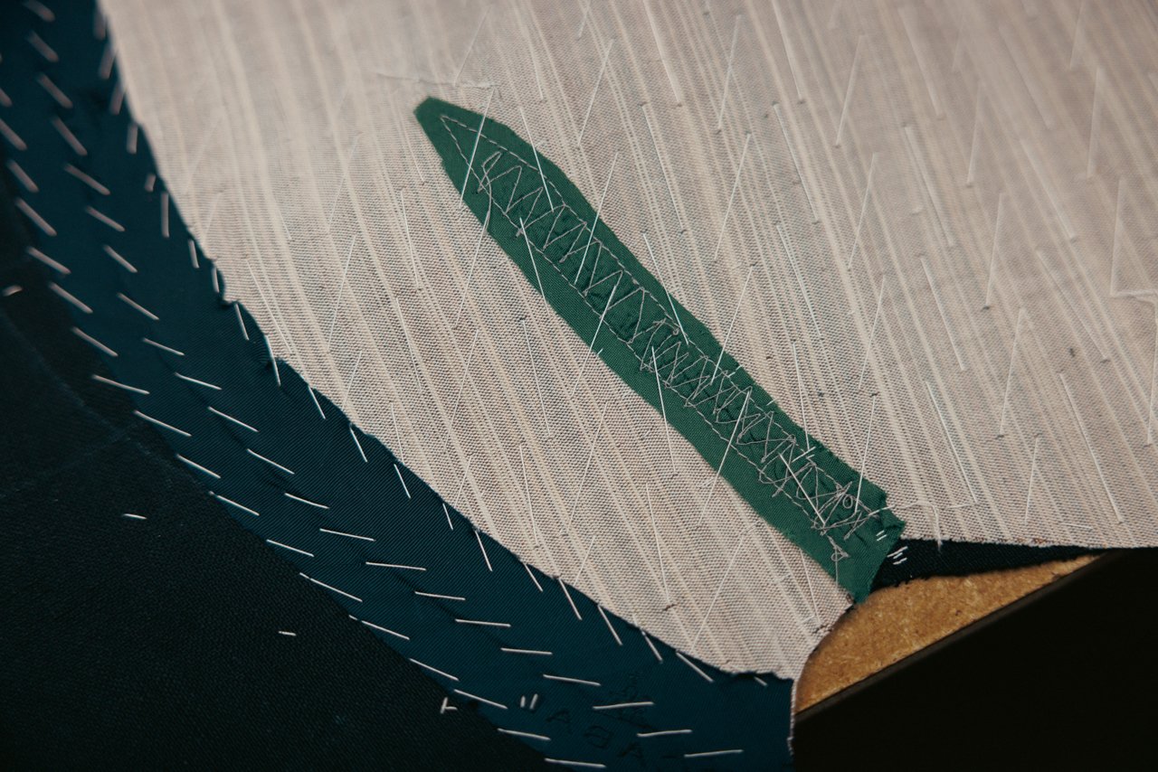 Close-up showing the internal structure: canvas and pad stitching on a bespoke lapel.
