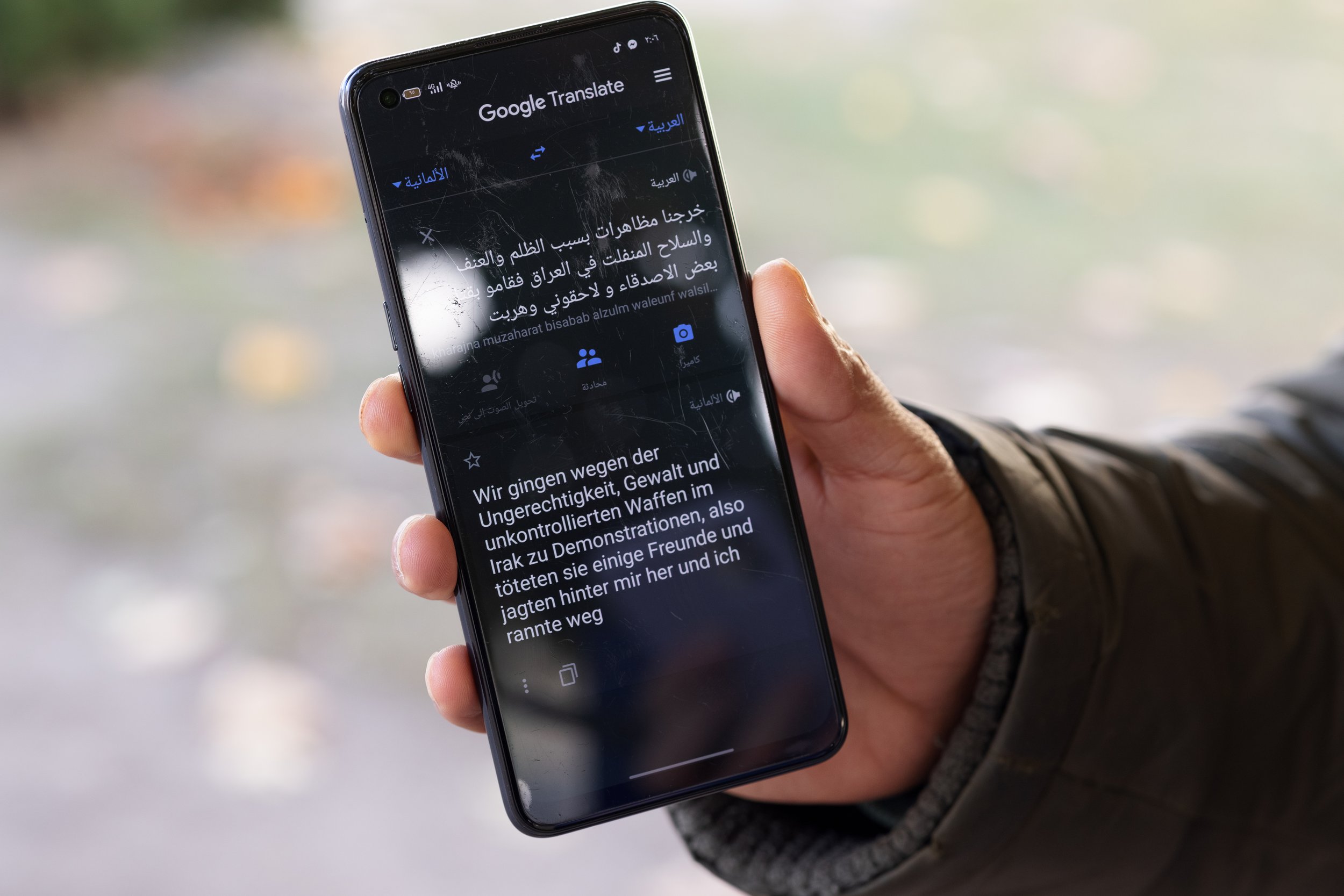 An Iraqi asylum seeker at Eisenhüttenstadt reception centre uses Google Translate to explain why he fled Iraq, Germany, 2021