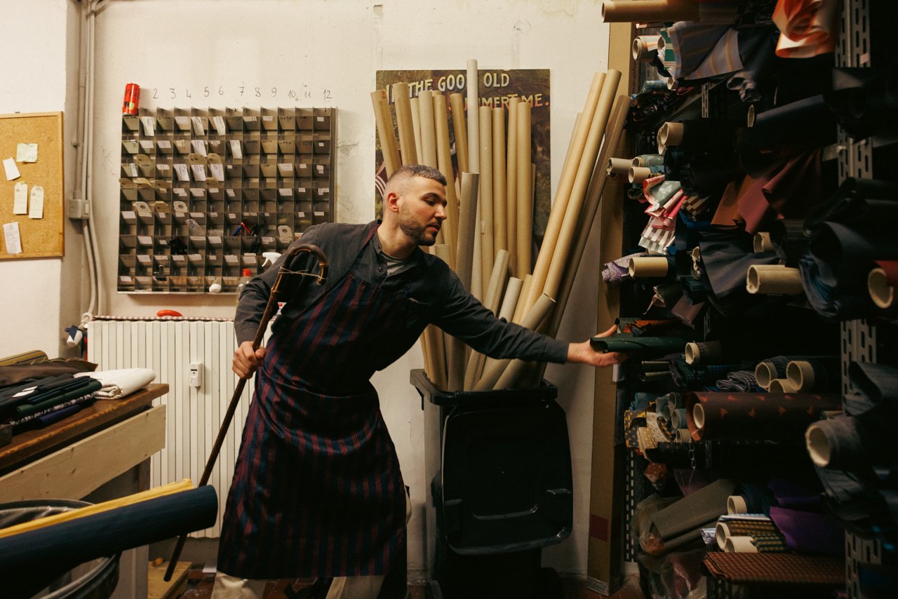 Francesco Maglia selecting a bolt of fabric from the extensive storage racks in the atelier.