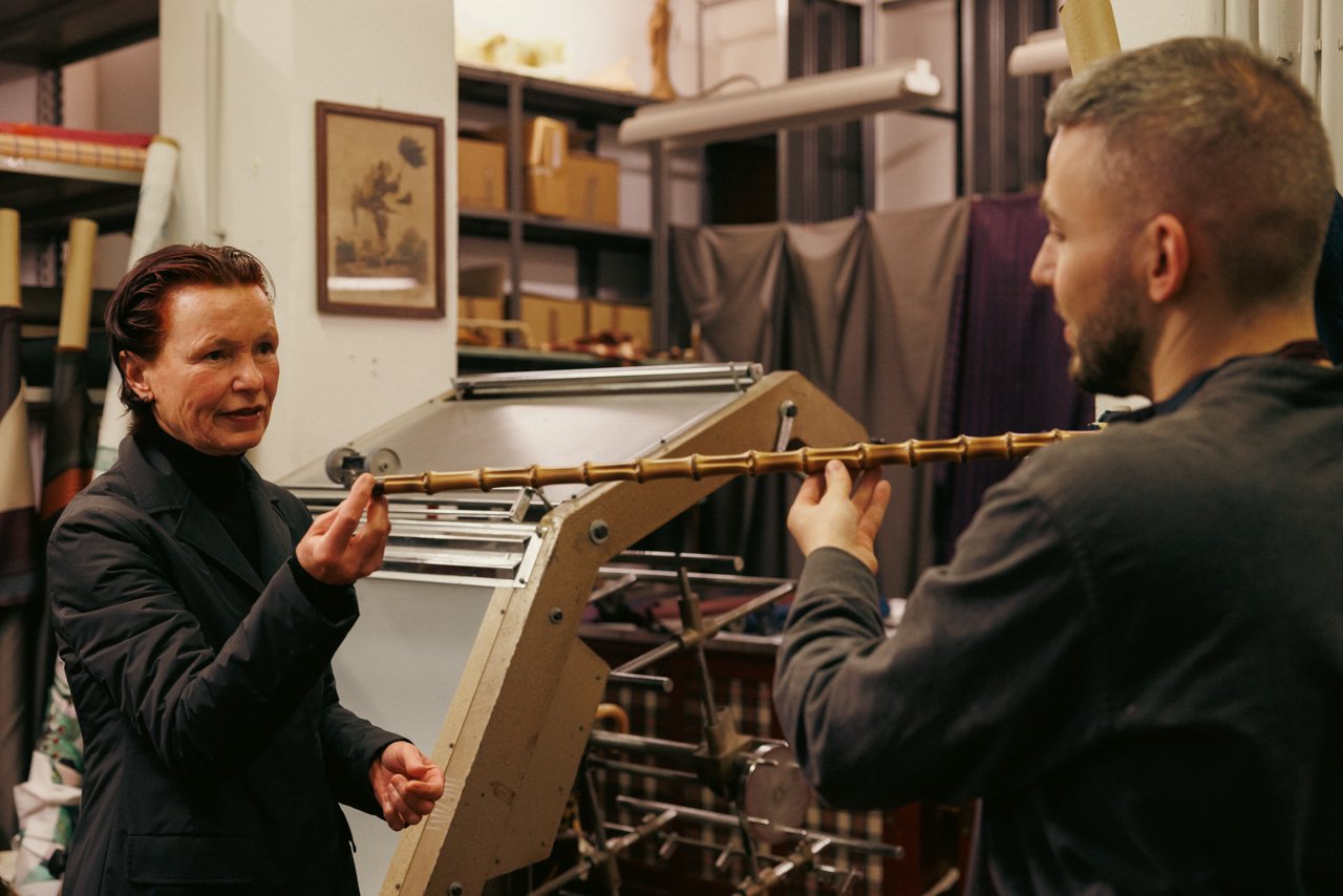 Francesco Maglia demonstrating the structure of an umbrella frame to another person.
