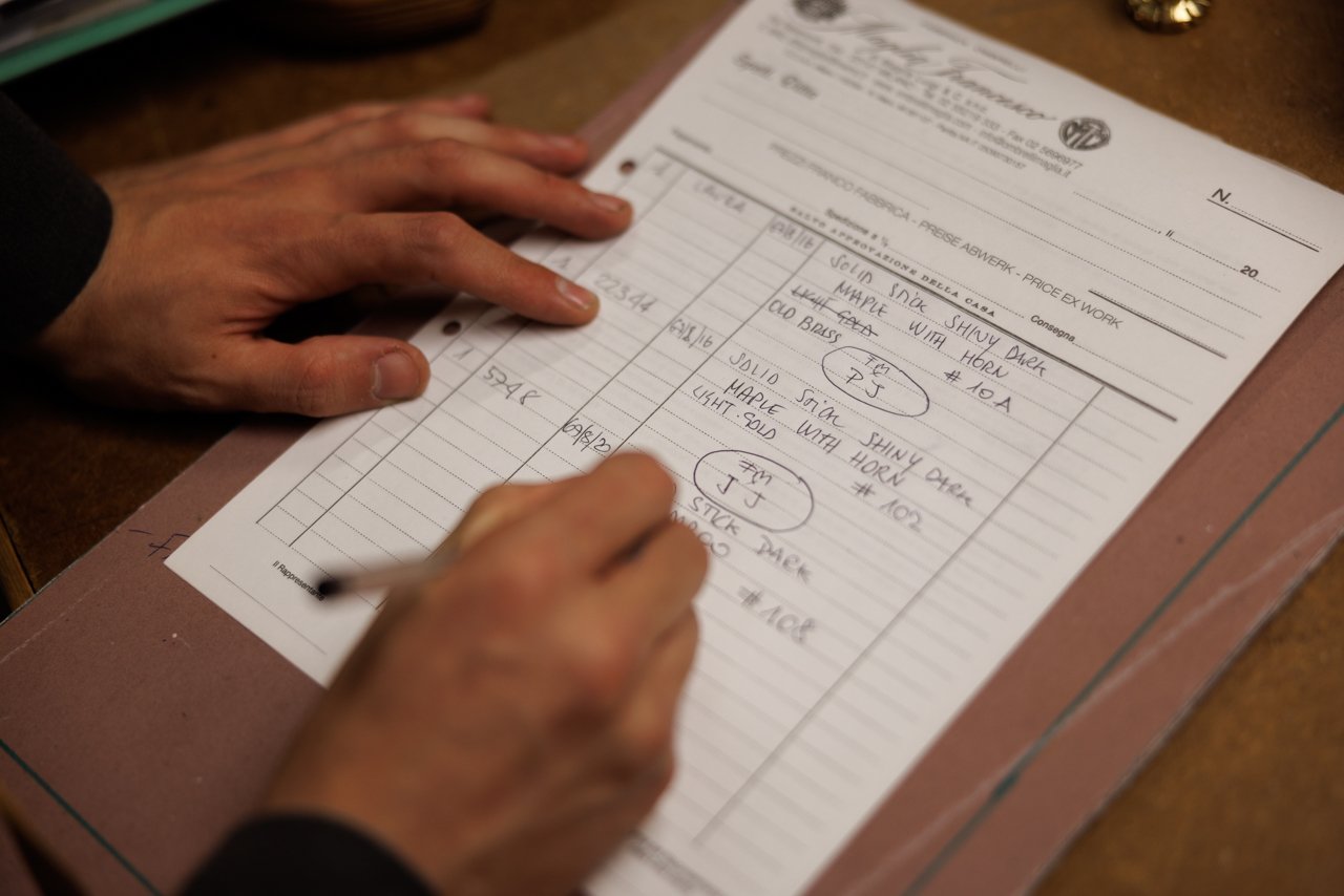 Close-up of a hand filling out a bespoke order form for a Maglia Francesco umbrella.