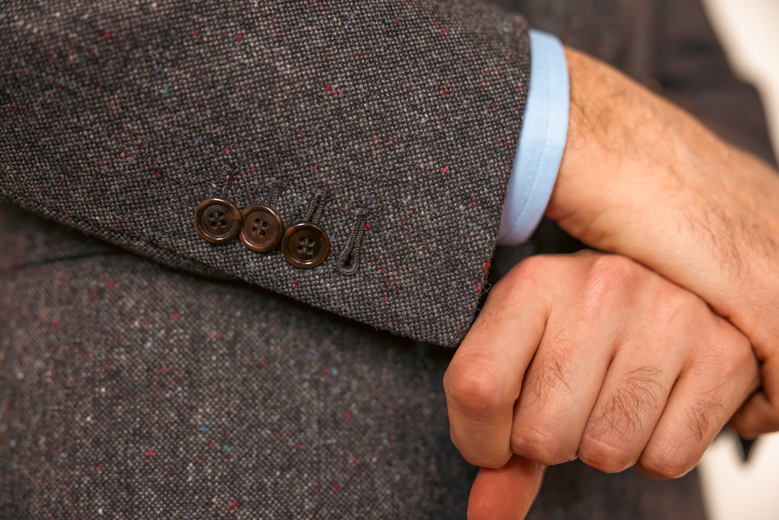 Close-up of surgeon's cuffs (functioning buttons) on a bespoke tweed jacket sleeve.