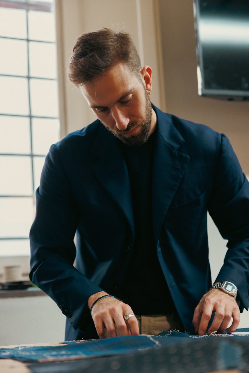 Man wearing a finished navy bespoke blazer, checking his watch.