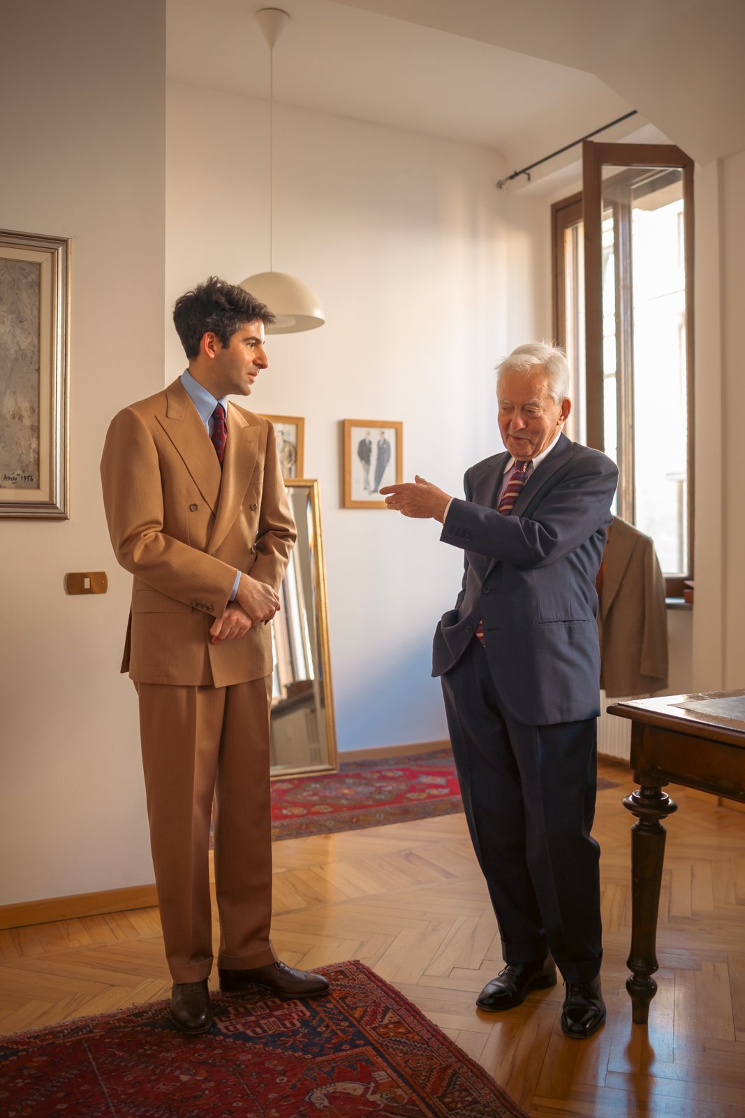 Francesco Musella giving tailoring advice to Gianfrancesco Musella-Dembech in the atelier.
