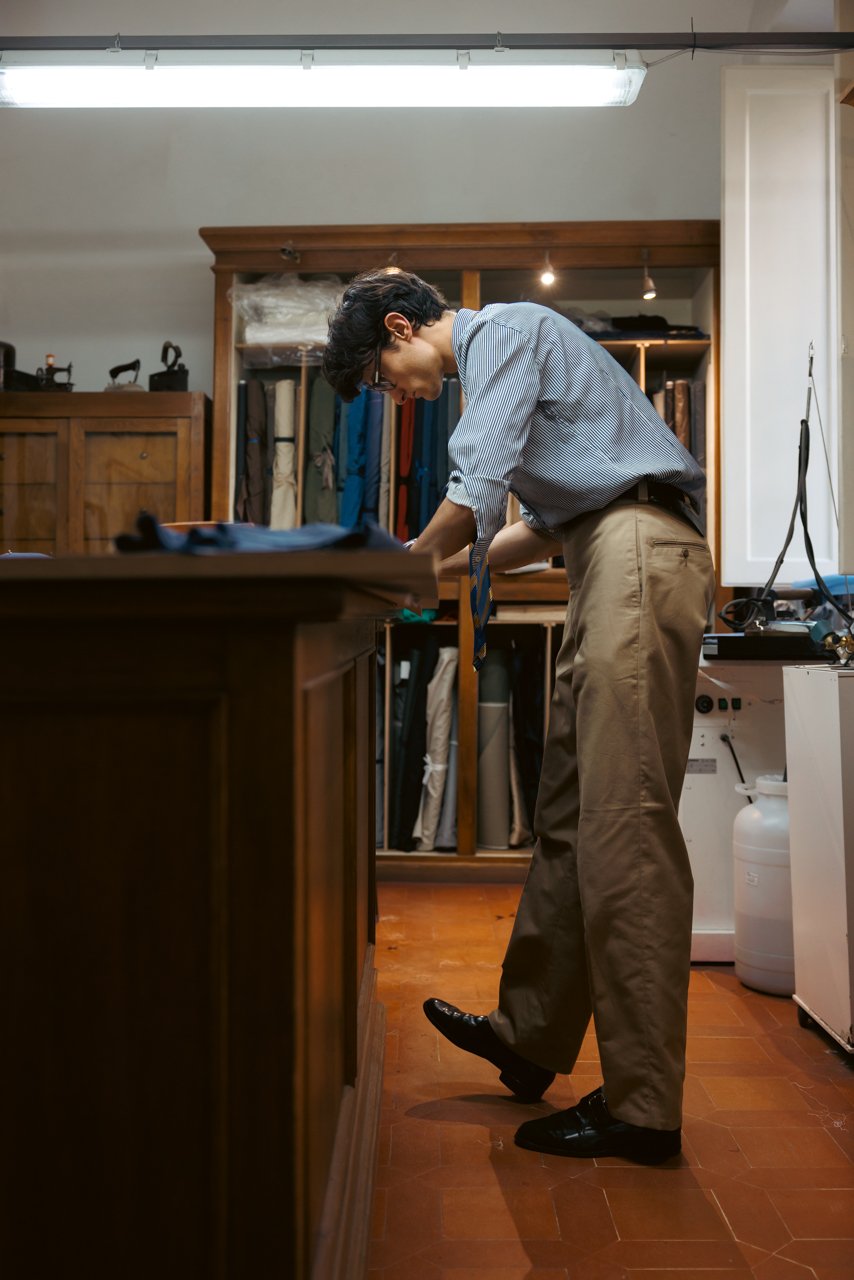 Tailor working at a high table in the Liverano workshop.