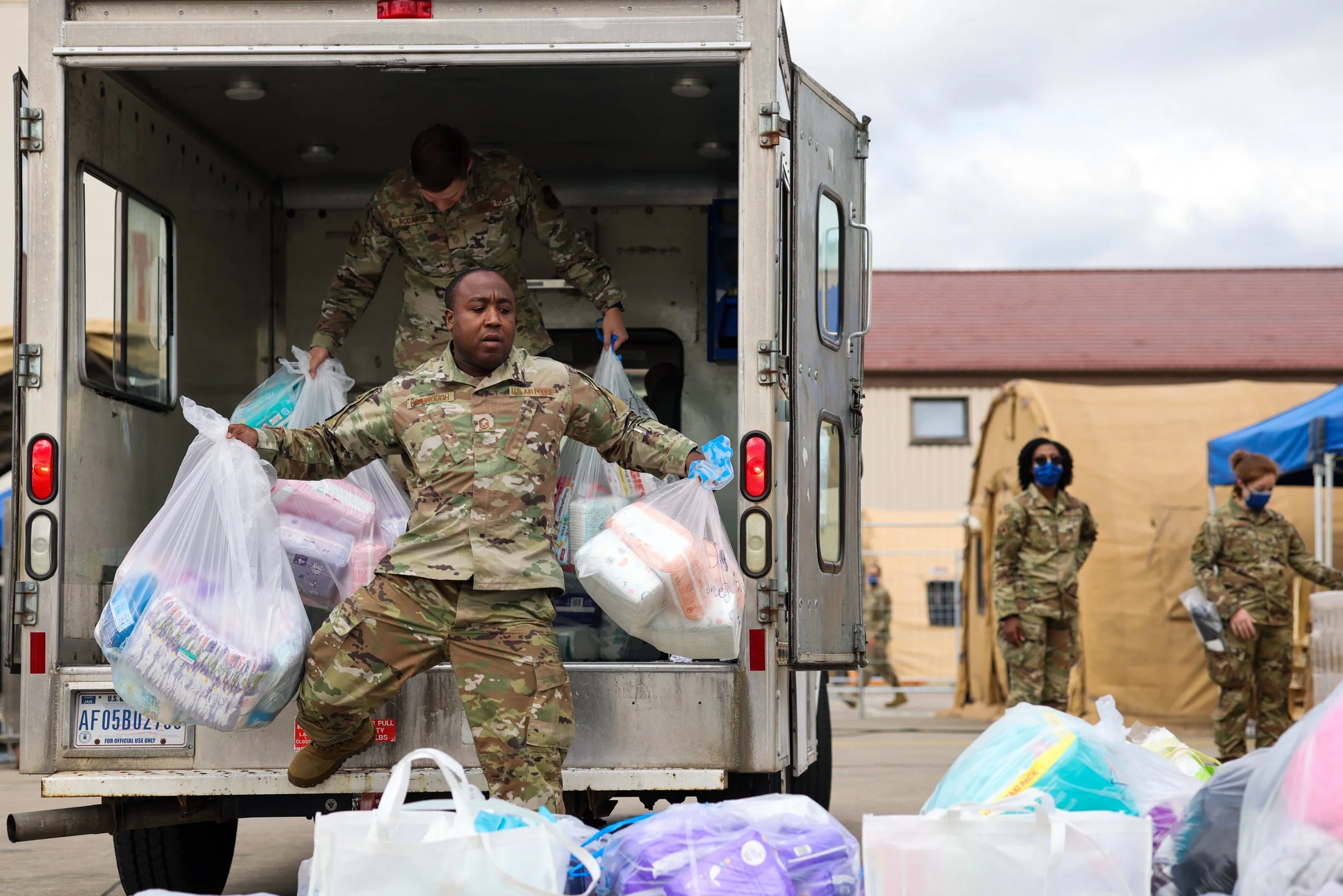 Military personnel unloading bags from a delivery truck during a refugee crisis in Ramstein American Airbase in Germany.