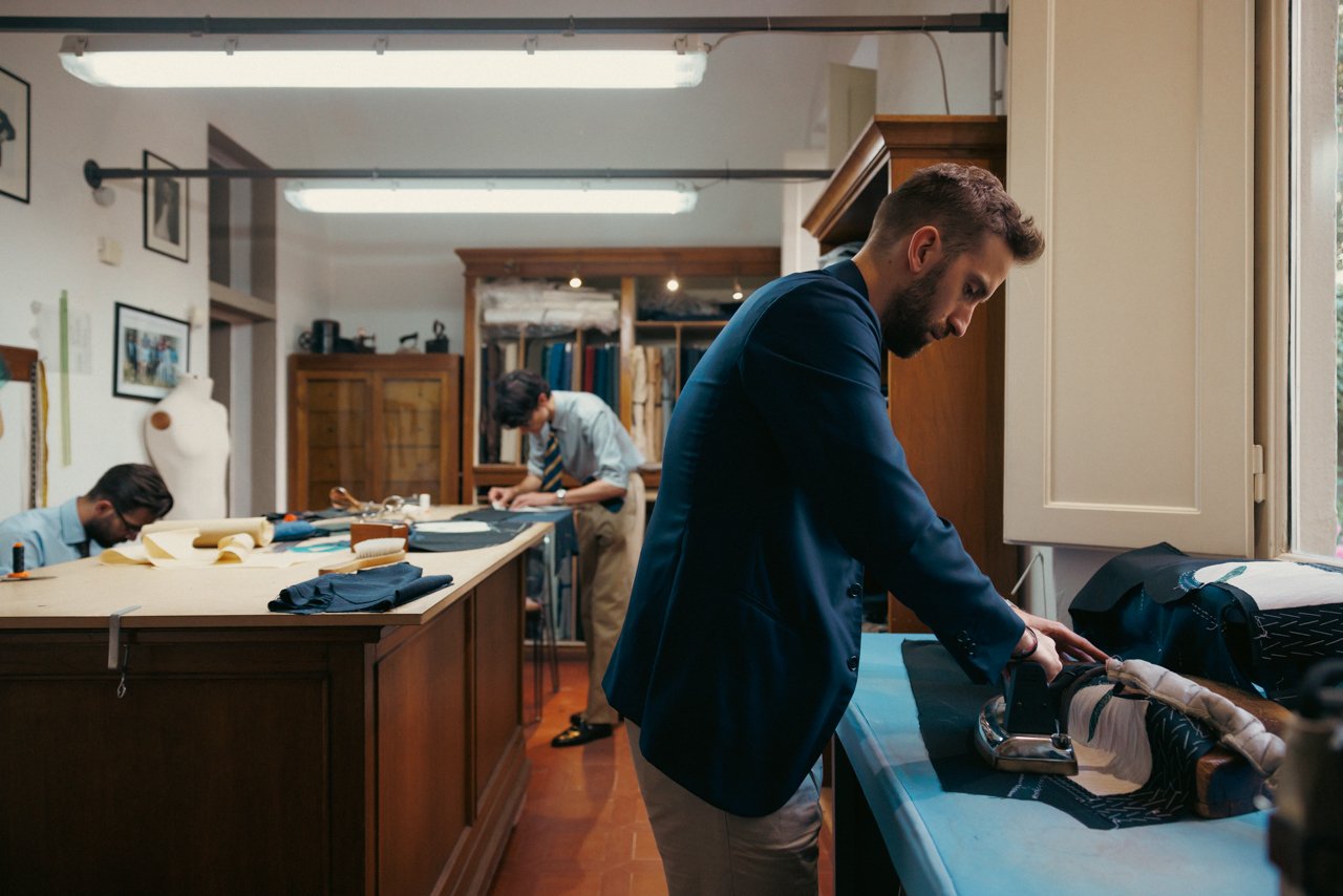 View of the Liverano workshop with tailors working at cutting tables.
