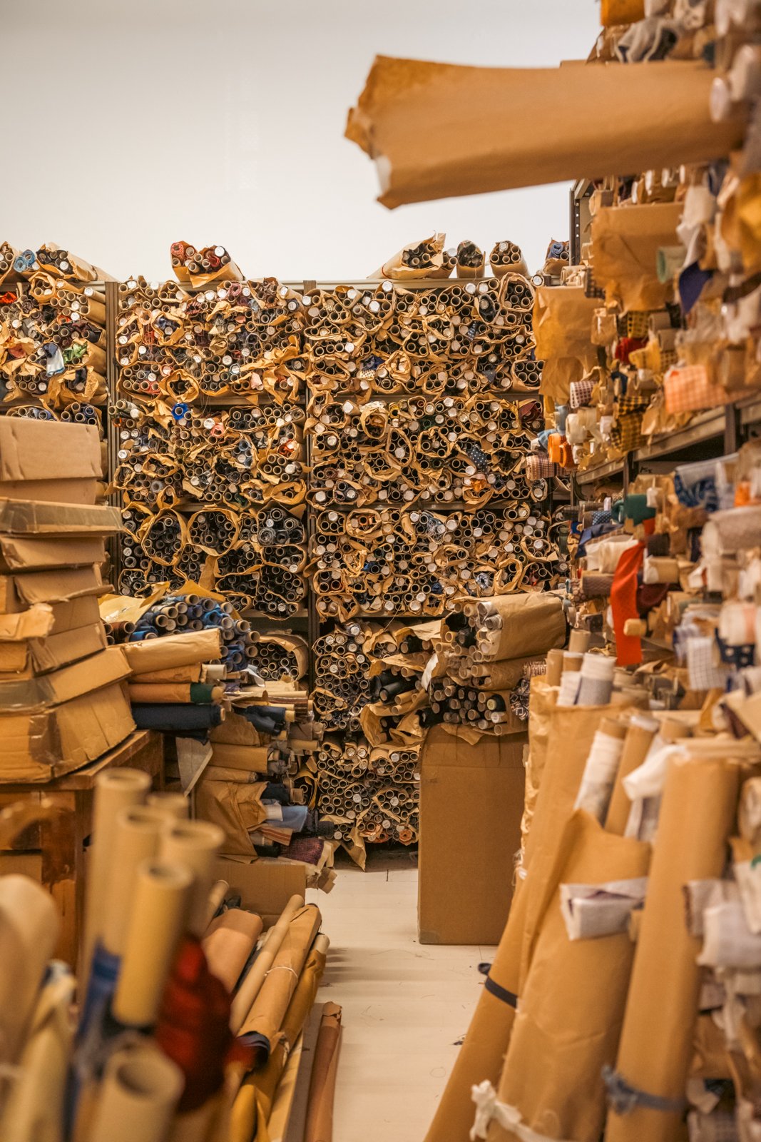 Vast storeroom at Petronius 1926, densely packed floor-to-ceiling with countless rolls of luxurious tie fabrics.
