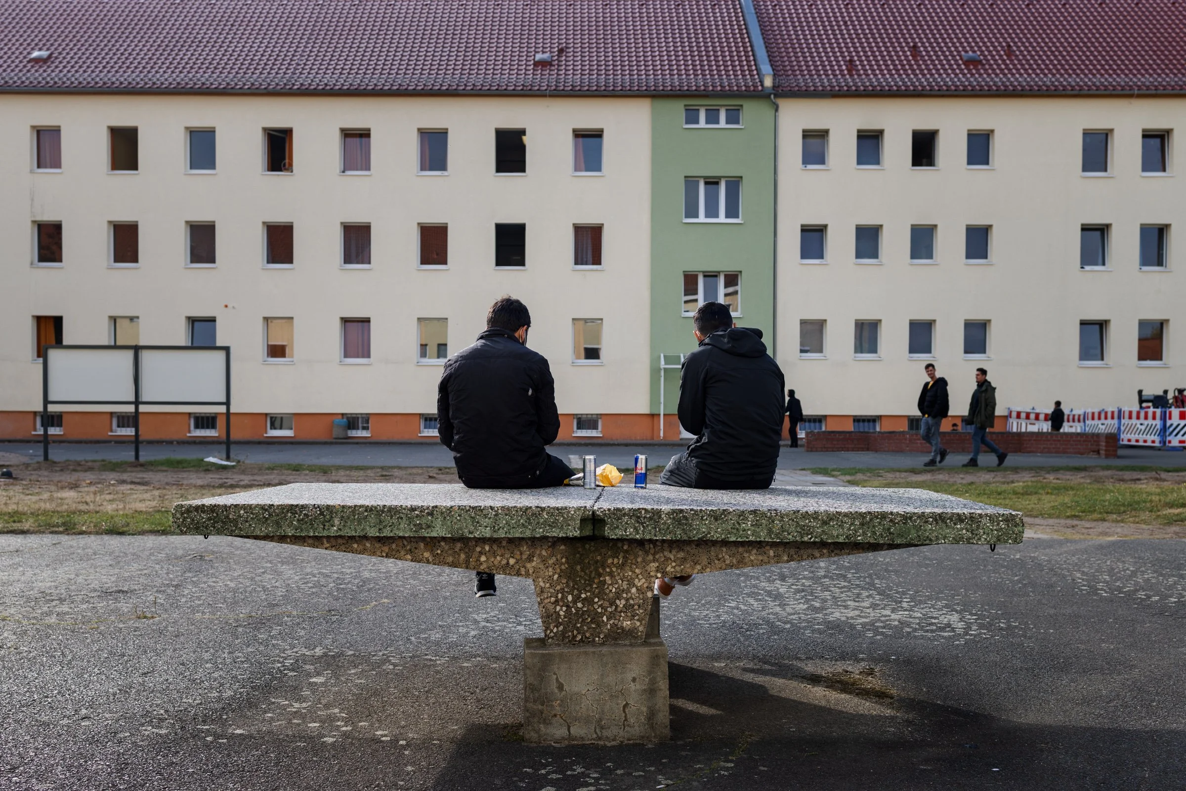 Asylum seekers wait in the courtyard of the Eisenhüttenstadt reception centre, eastern Germany, 2021. Many had crossed the Belarus-Poland border after weeks of violence and deprivation.