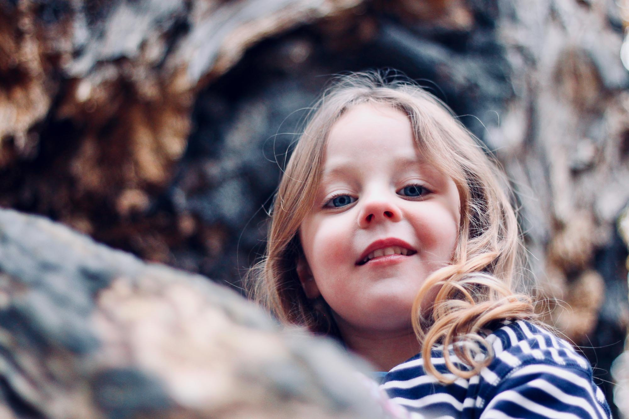family-portrait-young-girl-smiling-in-woods.jpg