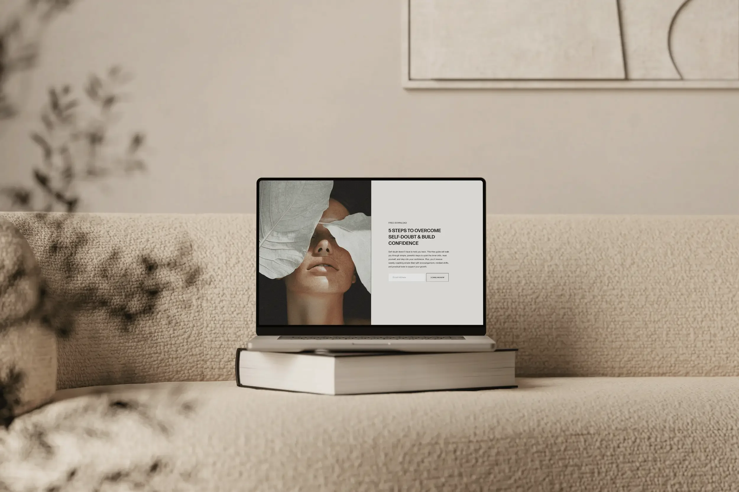 A laptop on a beige sofa displaying a website about overcoming self-doubt and building confidence.