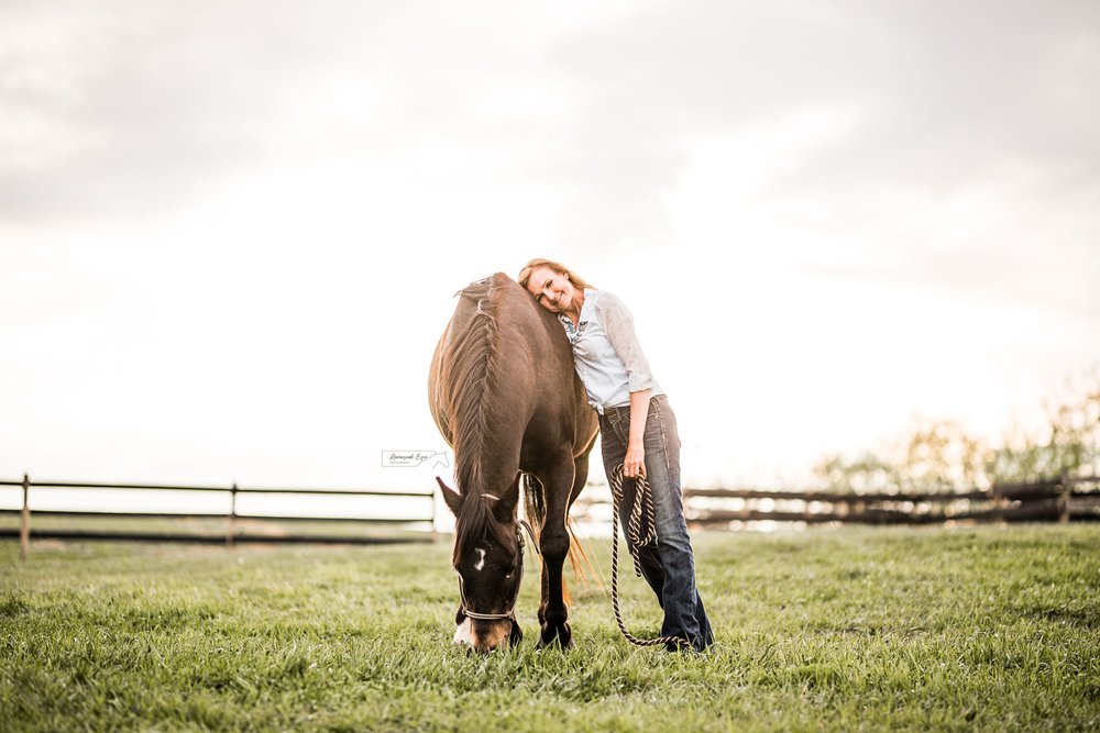 Woman and horse posing in field in Calgary.