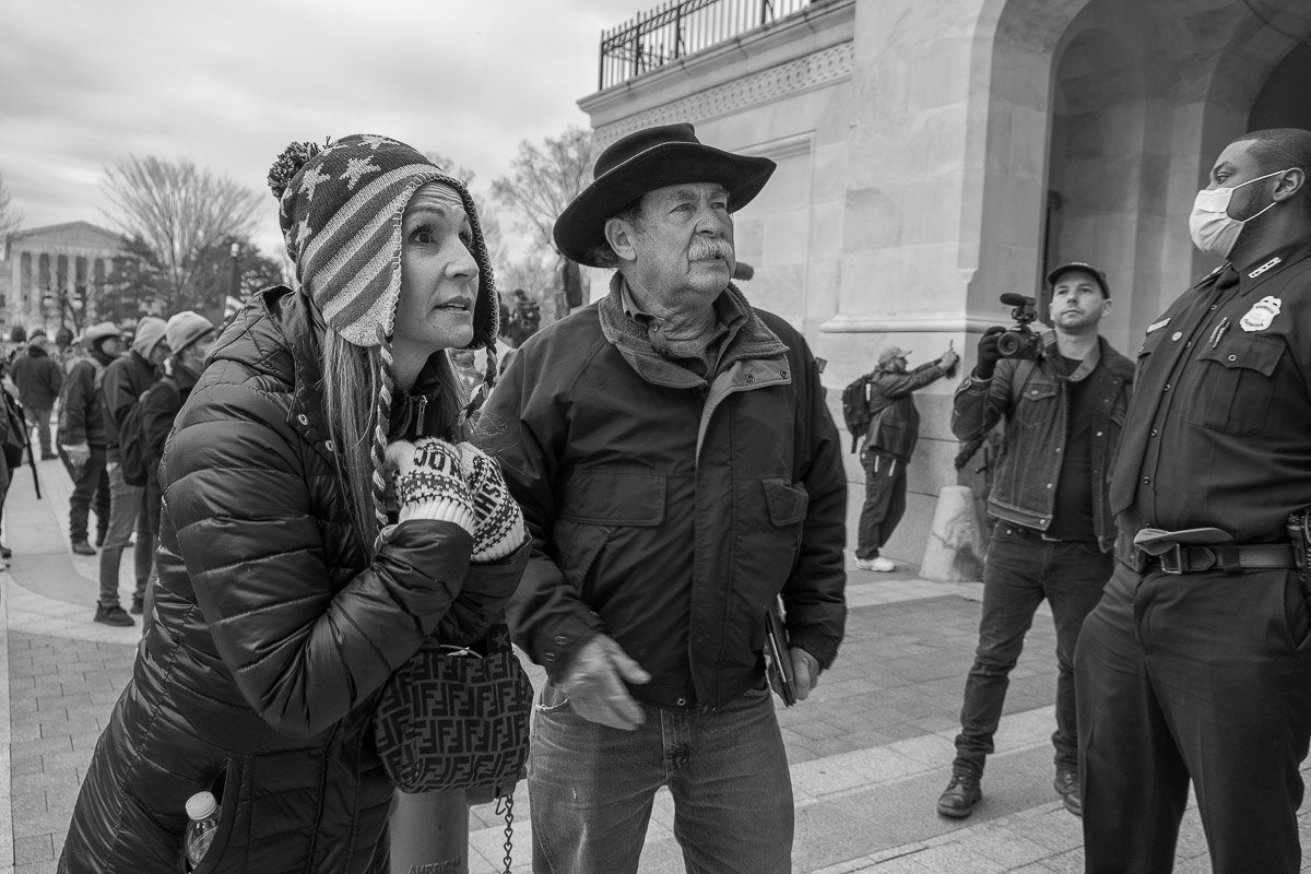 A couple of protesters confront riot police officers outside the west entrance of Capitol Hill. January 6, 2021, Washington, D.C.