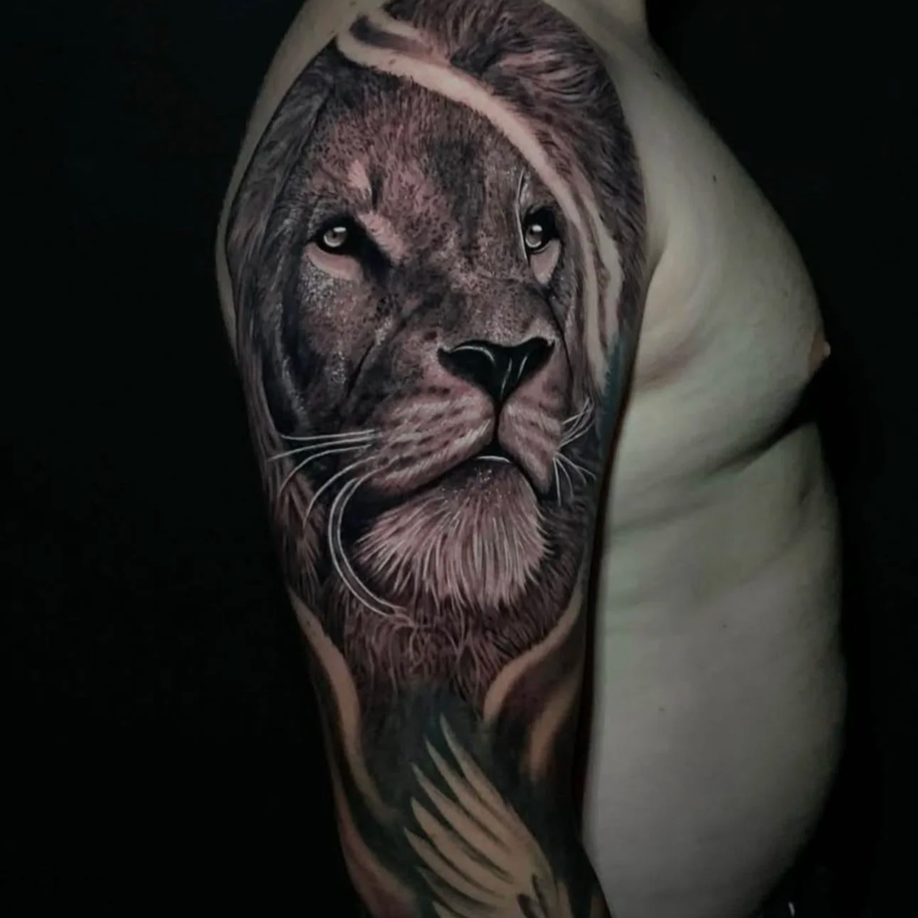 Tattoo of a lion's face on a person's arm.