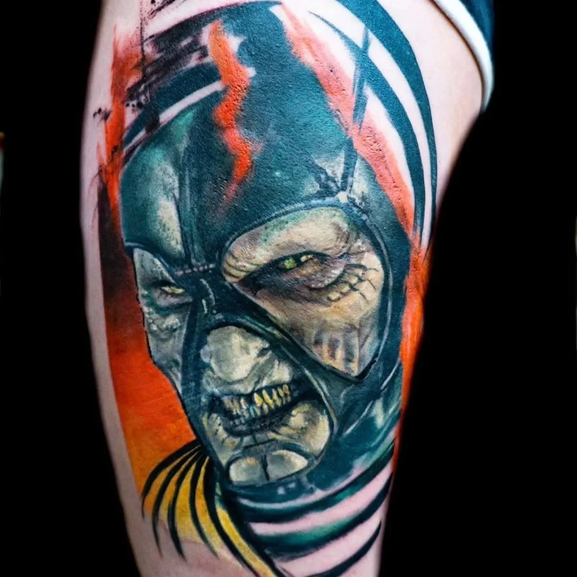 Colorful tattoo of a menacing clown with yellow eyes and greenish face, wearing a black helmet with orange streaks and a striped shirt.