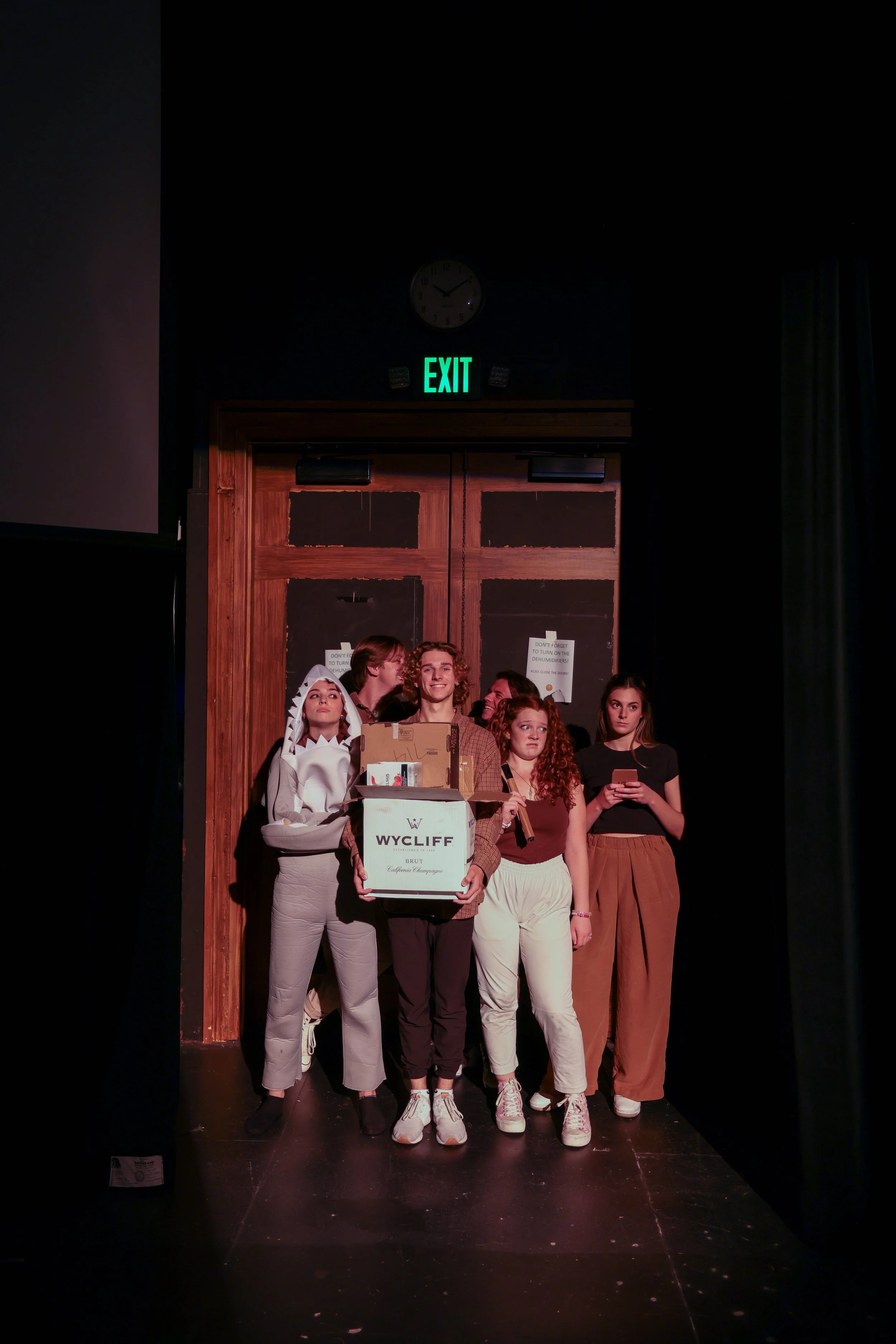 scene seven: all actors find themselves together in an elevator. from back to front, two actors stare at each other lovingly, a shark stands annoyed at the lack of space, a friendly neighbor brings home his groceries, a stoner smokes inside, and a te