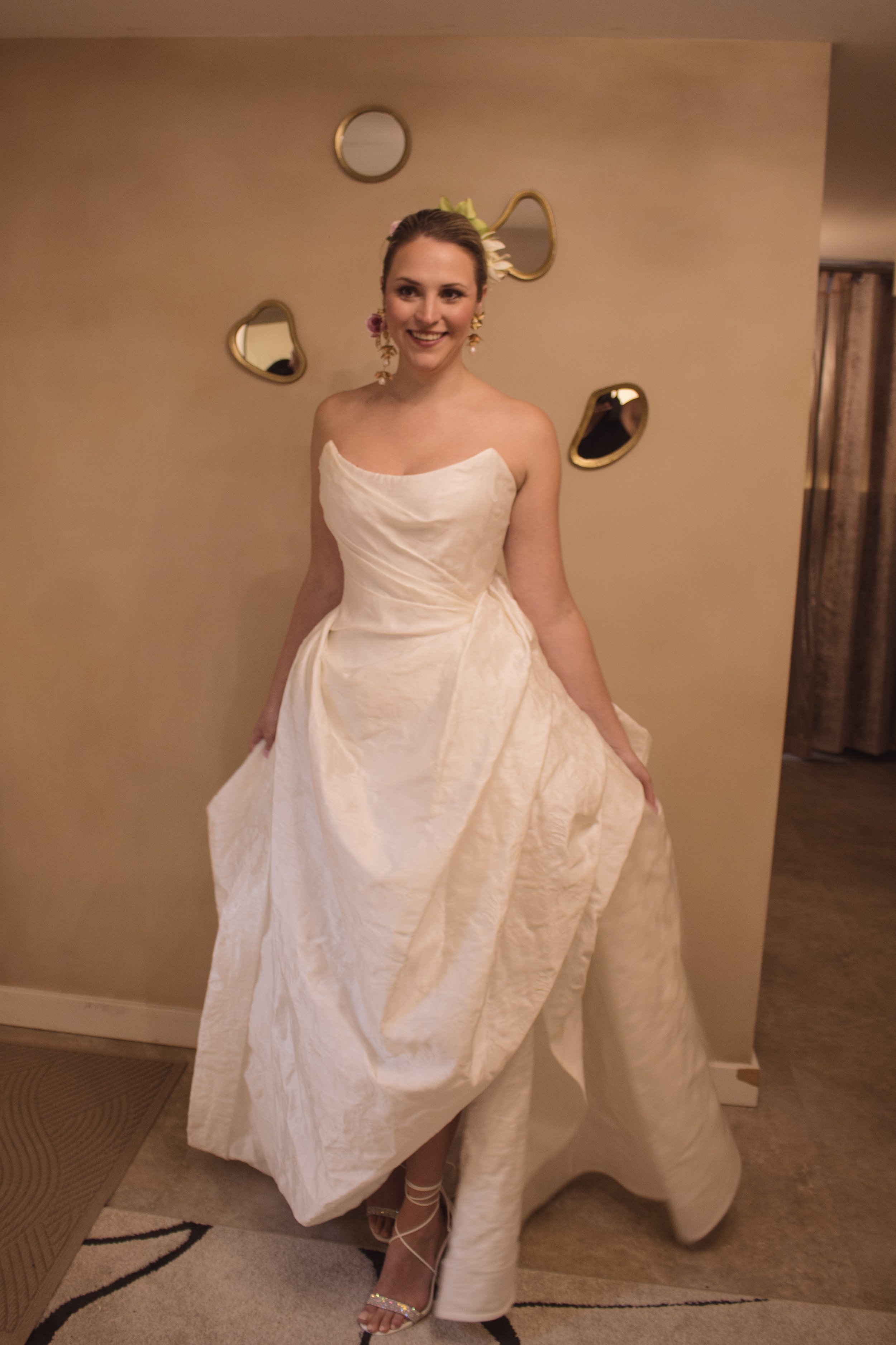 A bride trying on her custom high fashion wedding dress in a luxury private bridal boutique with couture designer and fit expert Angeline Brunk in her Queen Anne studio.