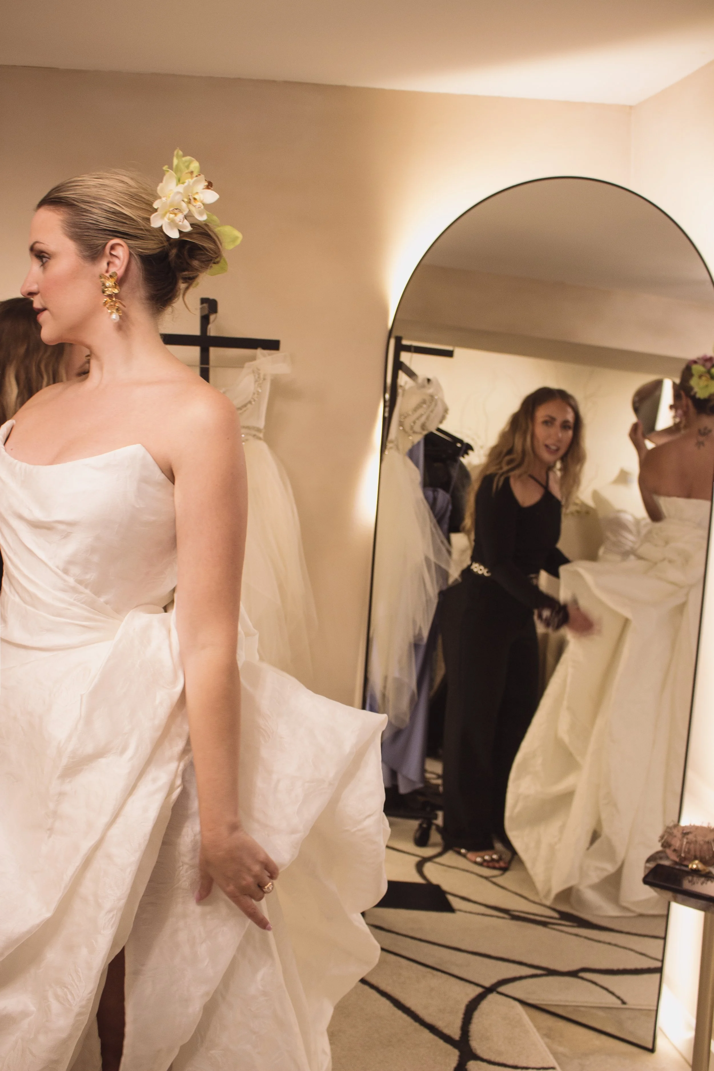 A bride trying on her custom high fashion wedding dress in a luxury private bridal boutique with couture designer and fit expert Angeline Brunk in her Queen Anne studio.
