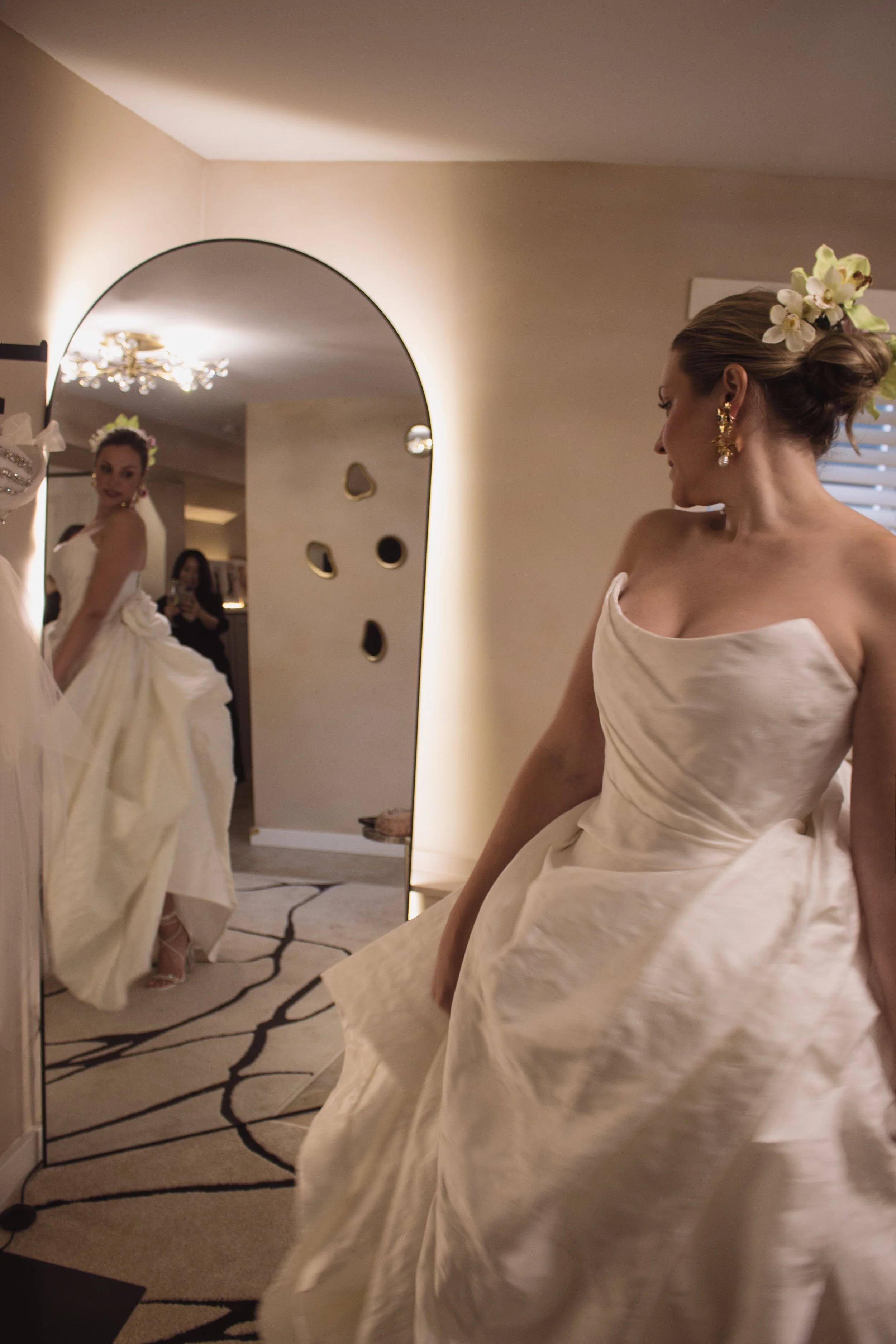 A bride trying on her couture high fashion wedding dress in a luxury private bridal boutique with couture designer and fit expert Angeline Brunk in her Queen Anne studio.