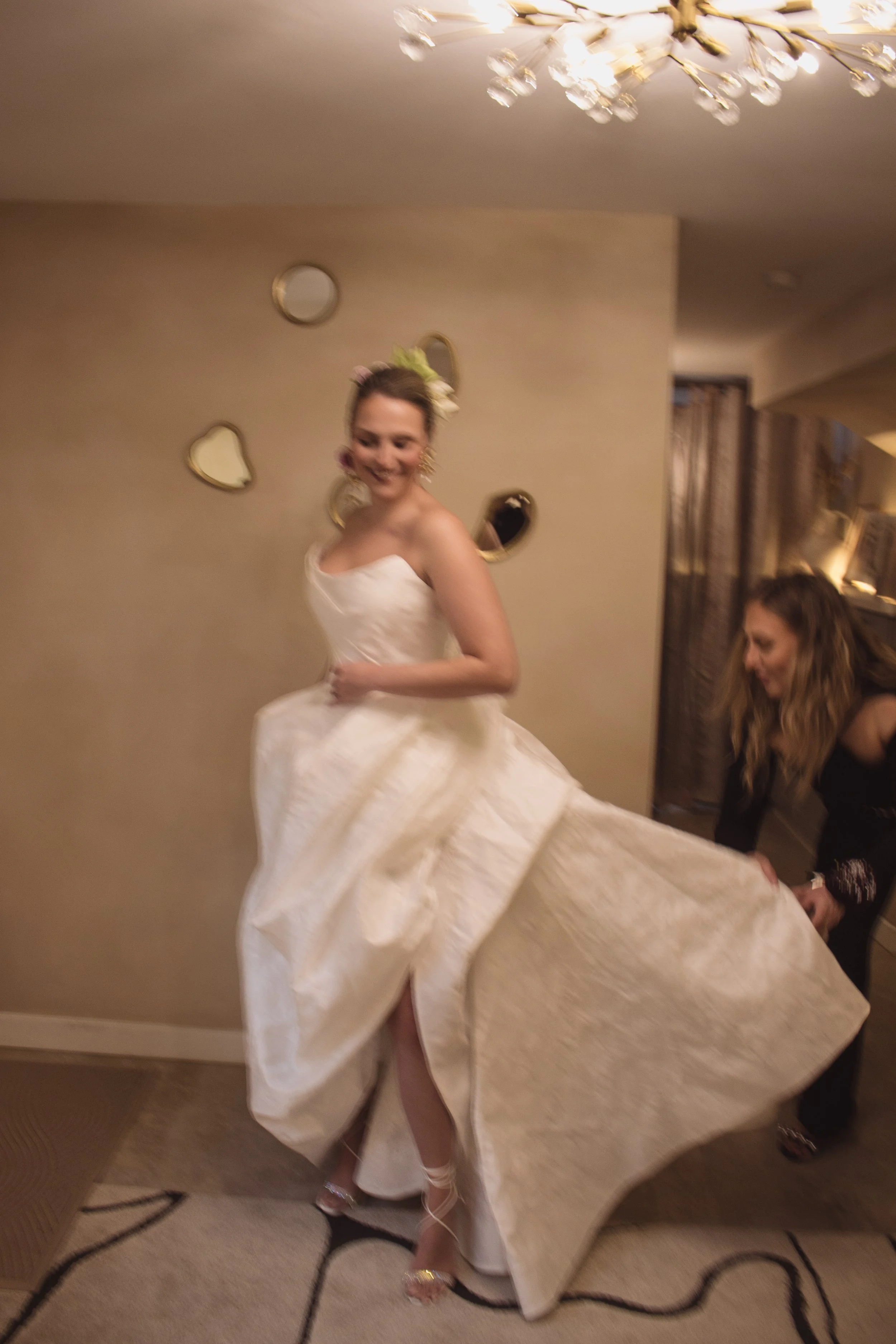 A bride trying on her custom high fashion wedding dress in a luxury private bridal boutique with couture designer and fit expert Angeline Brunk in her Queen Anne studio.