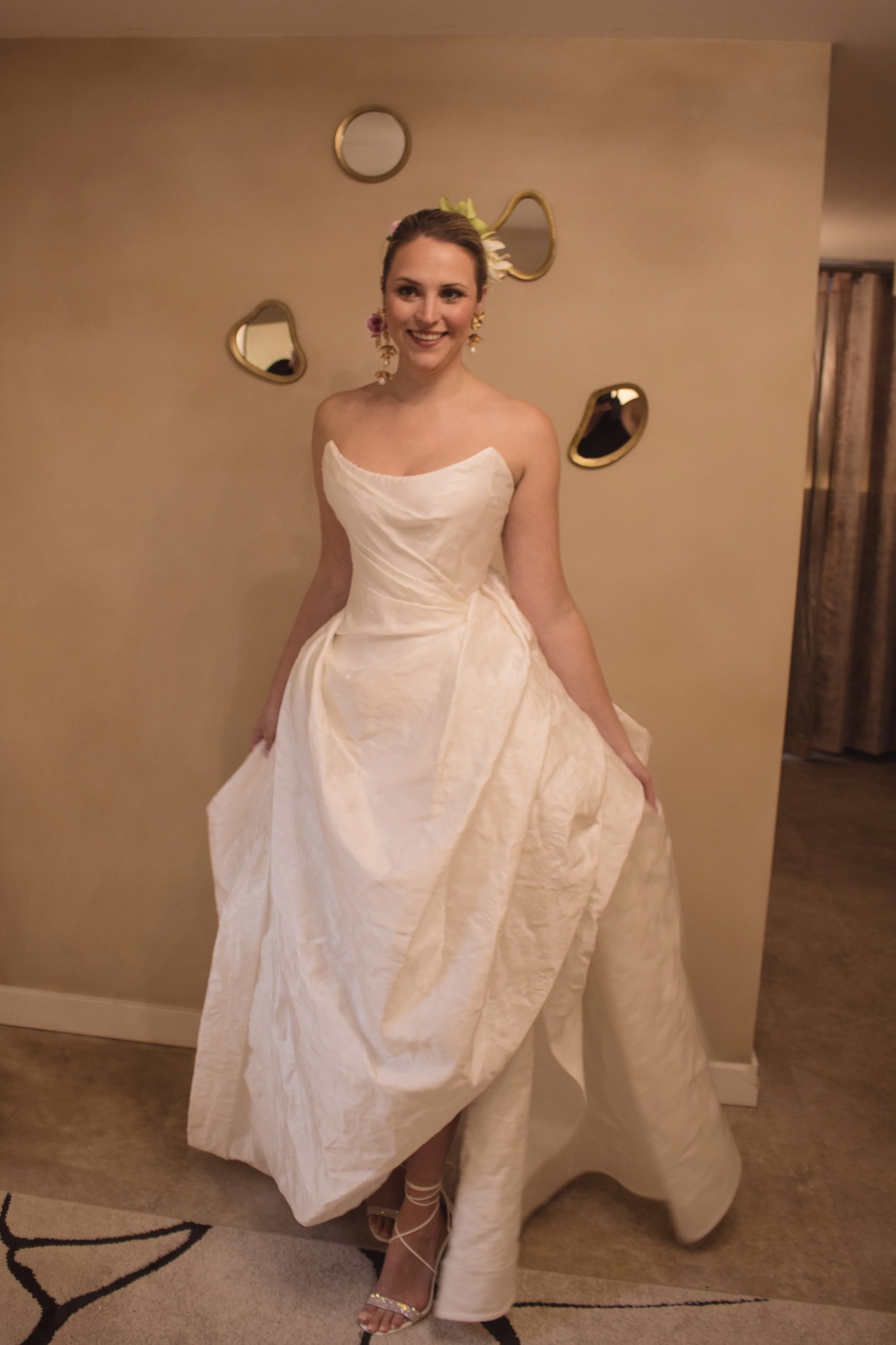 Strapless cat eye neckline gown with asymmetrically draped ball skirt featuring a slit and rose draped bustle in back by Kirkland designer Angeline Brunk serving women in the PNW looking for high fashion bridal and evening wear.