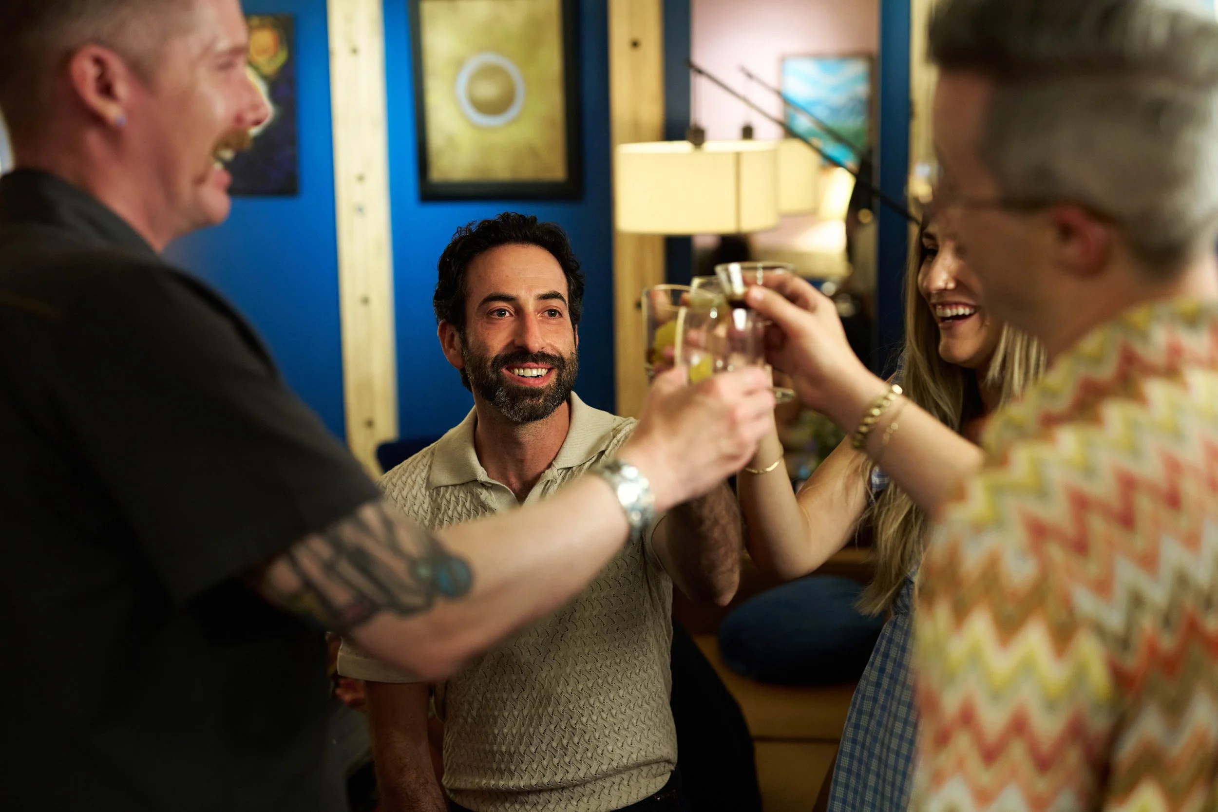 Guests smiling and raising a toast together inside Broderick’s warm, inviting lounge.