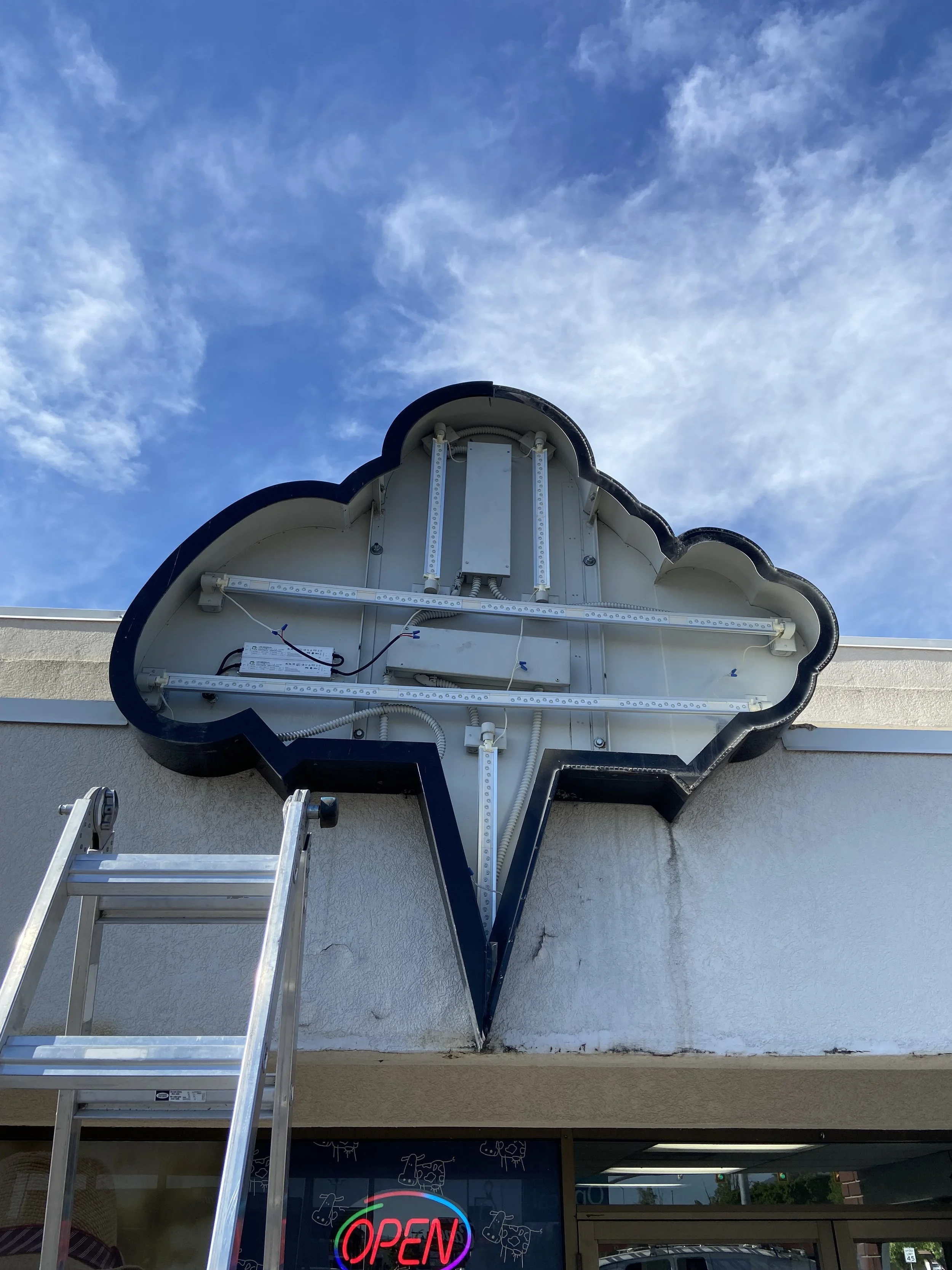 The photo shows a sign repair for Charlie's Ice Cream in Logan Utah