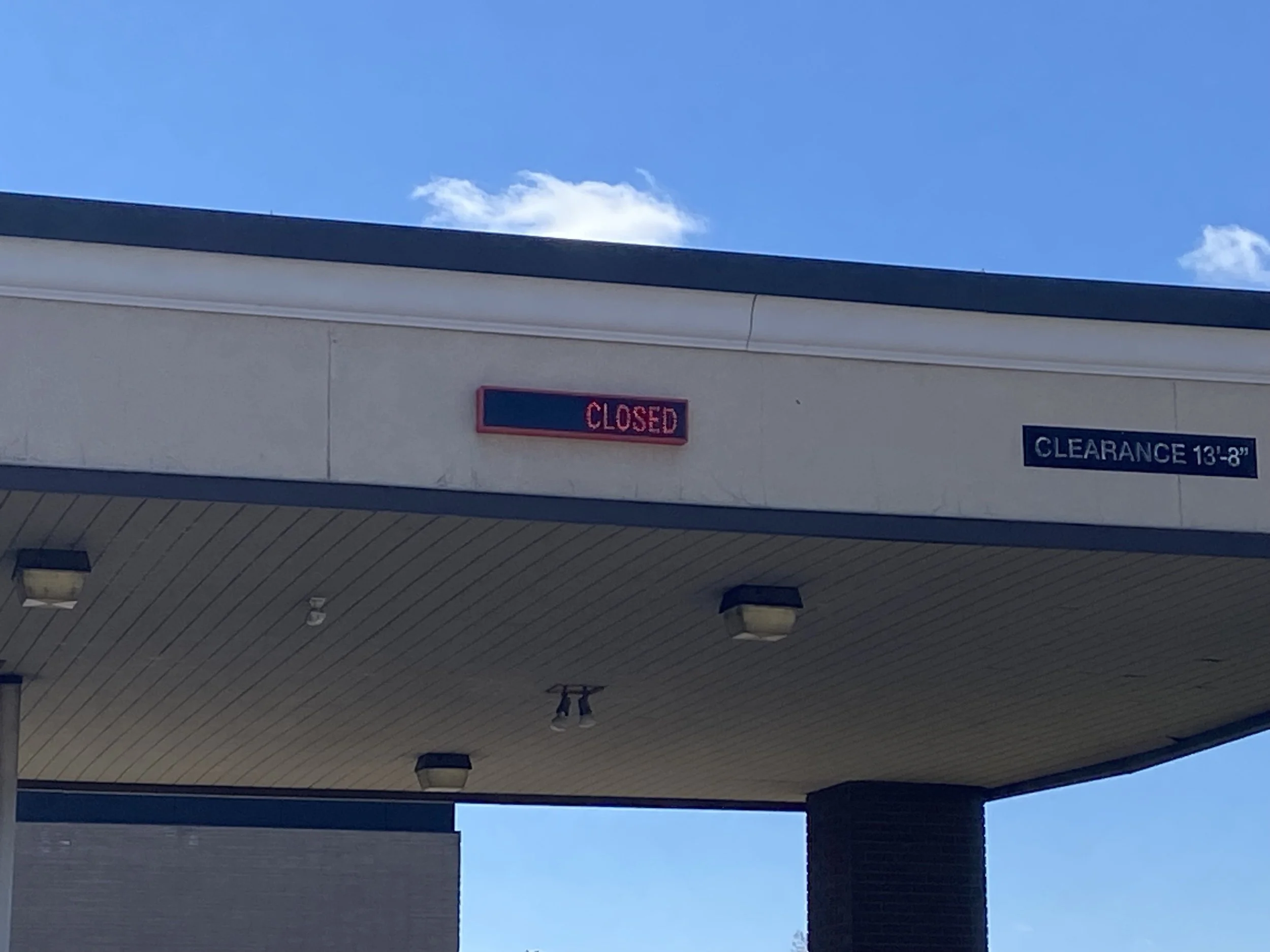 Part of a building exterior with a ledge and a electronic teller sign
