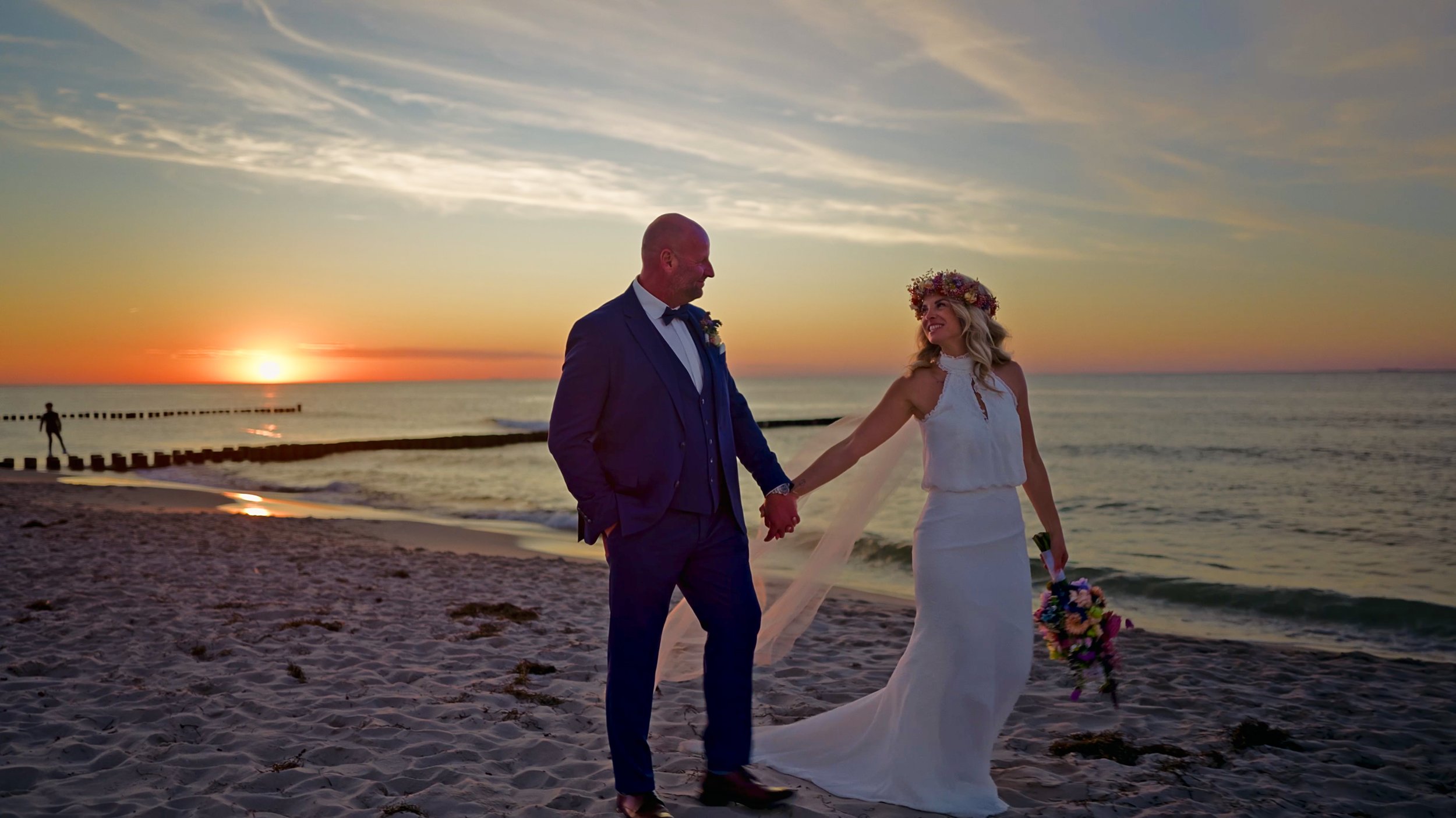 Brautpaar spaziert am Strand. Sonnenuntergant an der Ostsee, Ahrenshoop. Hochzeitsvideo LoCrew