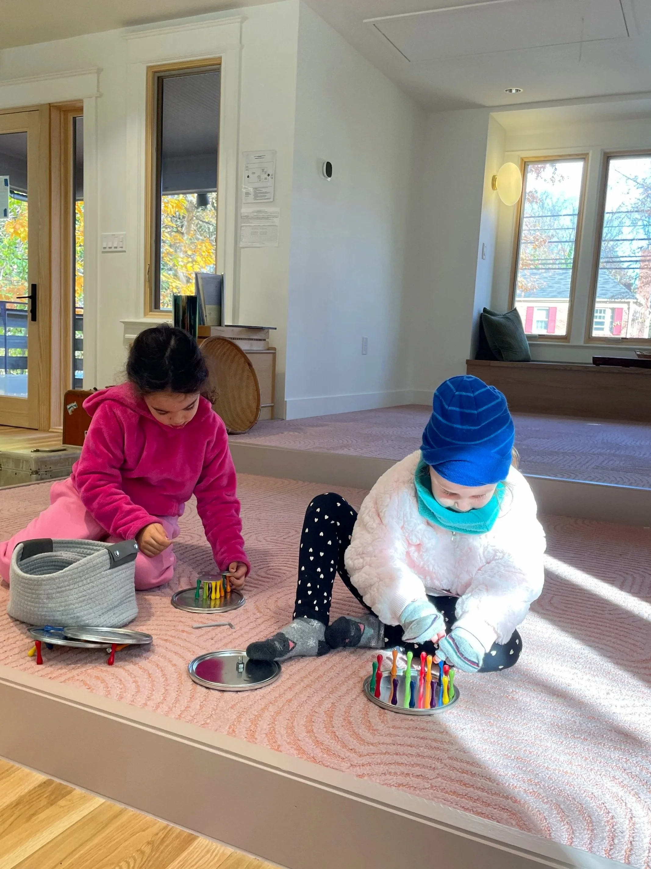 Children playing in the newly renovated indoor nature space at Takoma Park Cooperative Nursery School, exploring and engaging with natural materials