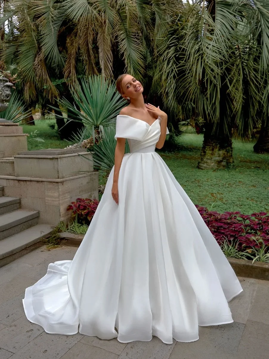 The Tavira Gown: Timeless Grace with Effortless Modern Romance

The Tavira gown is crafted for the curvy bride who desires pure elegance, soft structure, and a beautifully flattering silhouette. With its sculpted off-the-shoulder neckline and luxurio