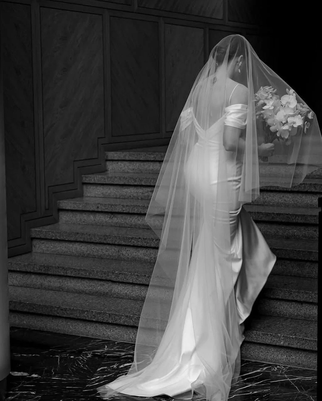 The &Aacute;vila wedding dress is the epitome of elegance and minimalism. Its off-the-shoulder design and softly draped neckline exude sophistication, highlighting feminine grace. The sleek silhouette ensures a timeless look, perfect for a bride who 