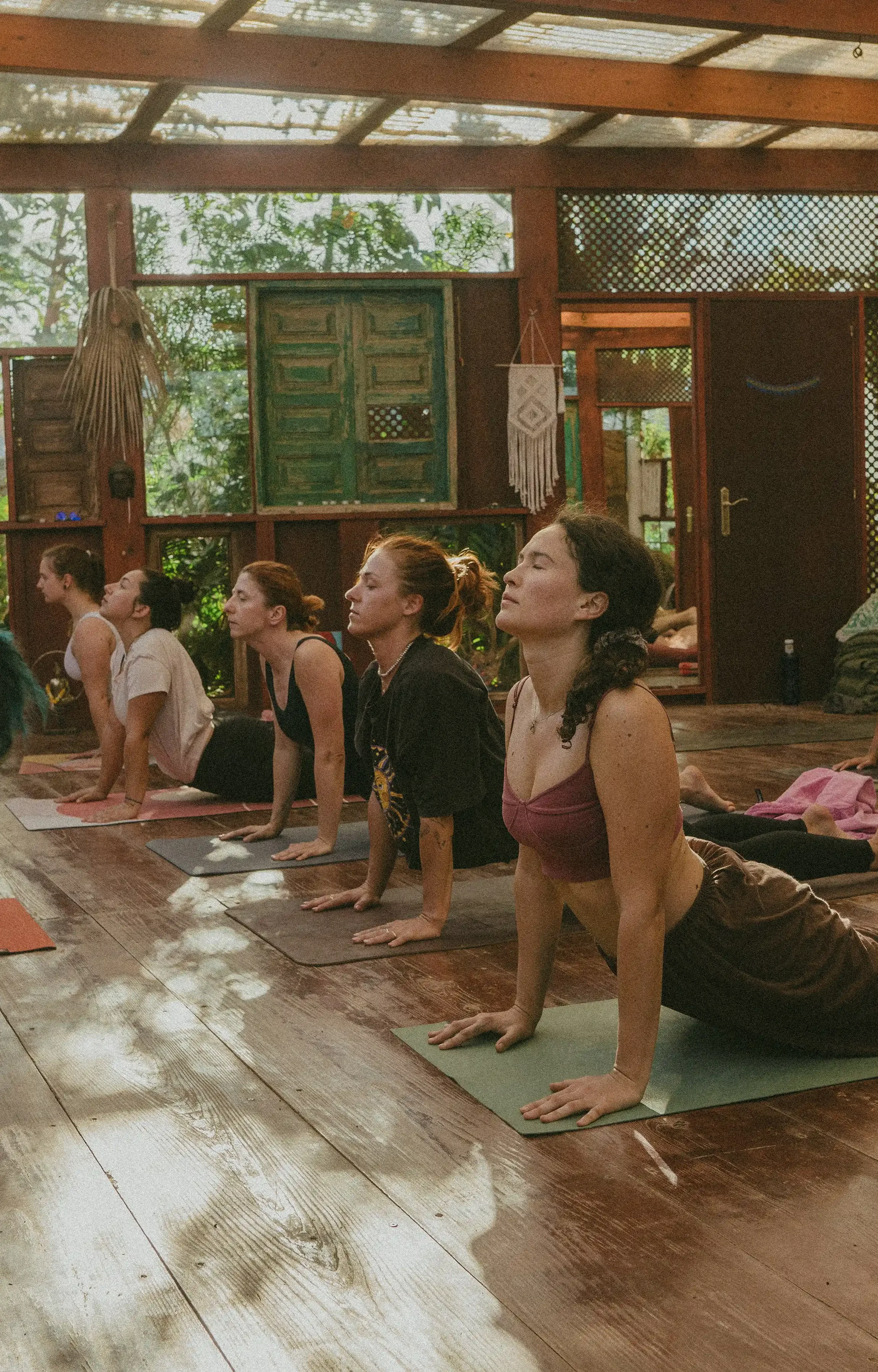 Šťastná skupina žen cvičících jógu a meditaci na jóga retreatu asi.Joga. Radost z komunity, relaxace a sdílené energie.