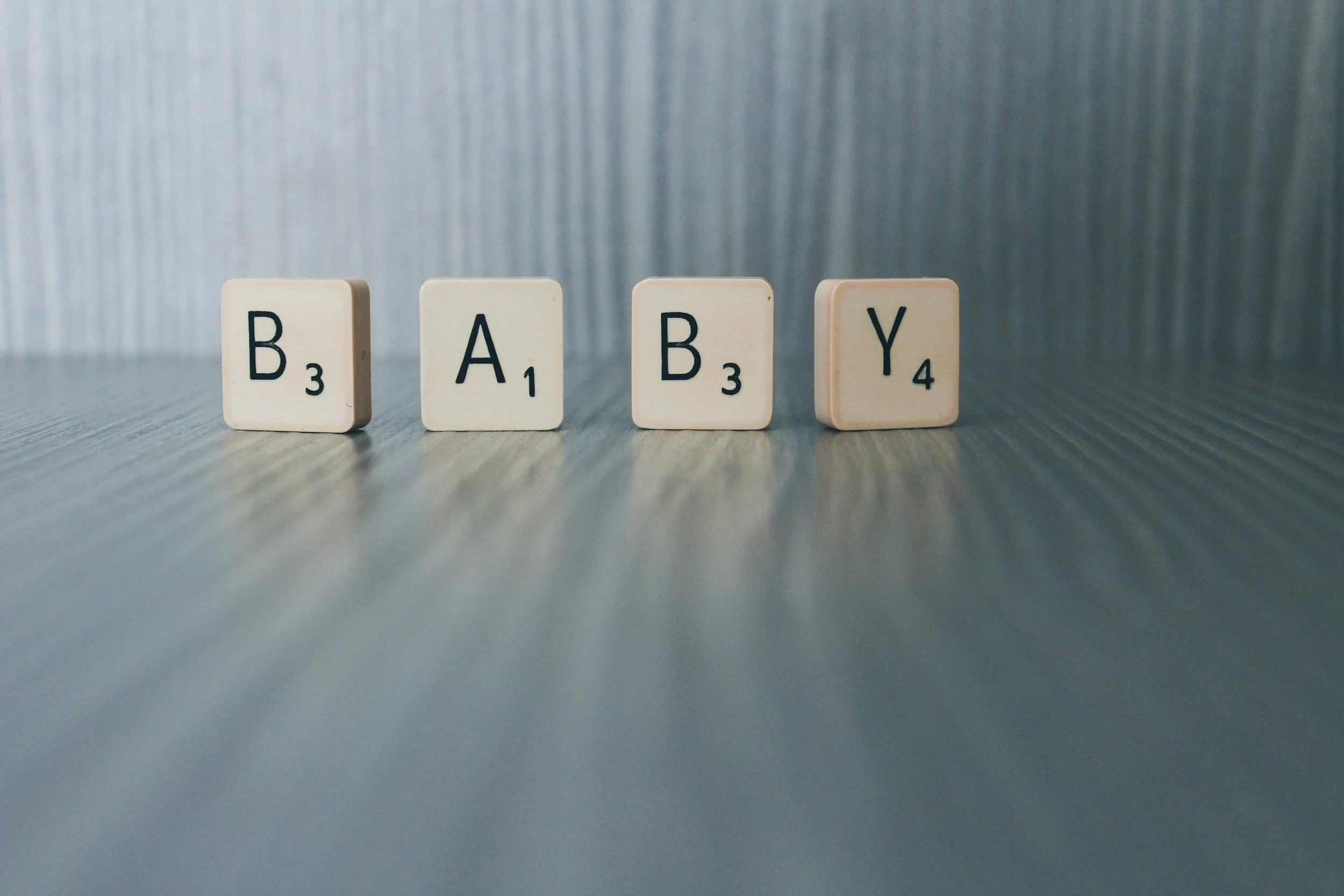 Scrabble letters that spell 'baby' featured in a blog about when should you start your baby registry.
