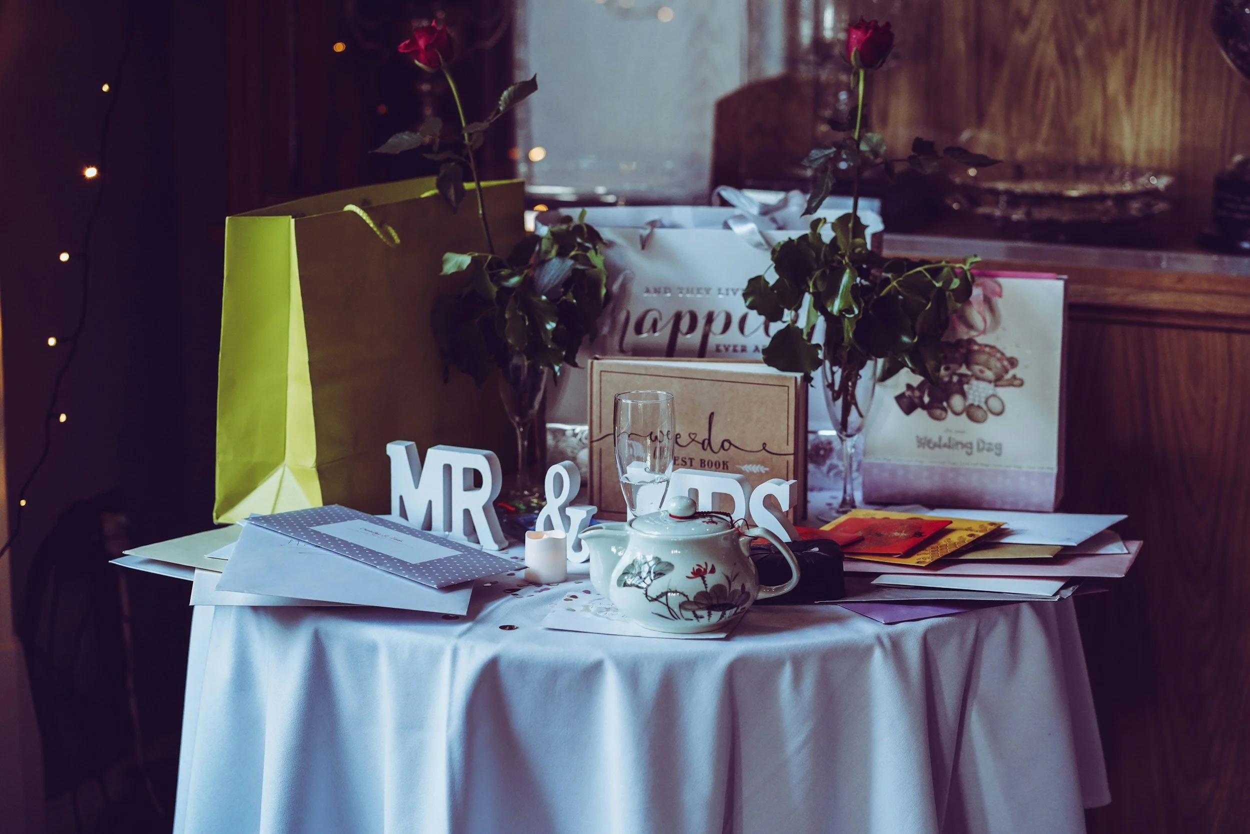 A wedding gift table covered in presents featured in a blog called 'When to Start Your Wedding Registry' by Grateful Heart Company.