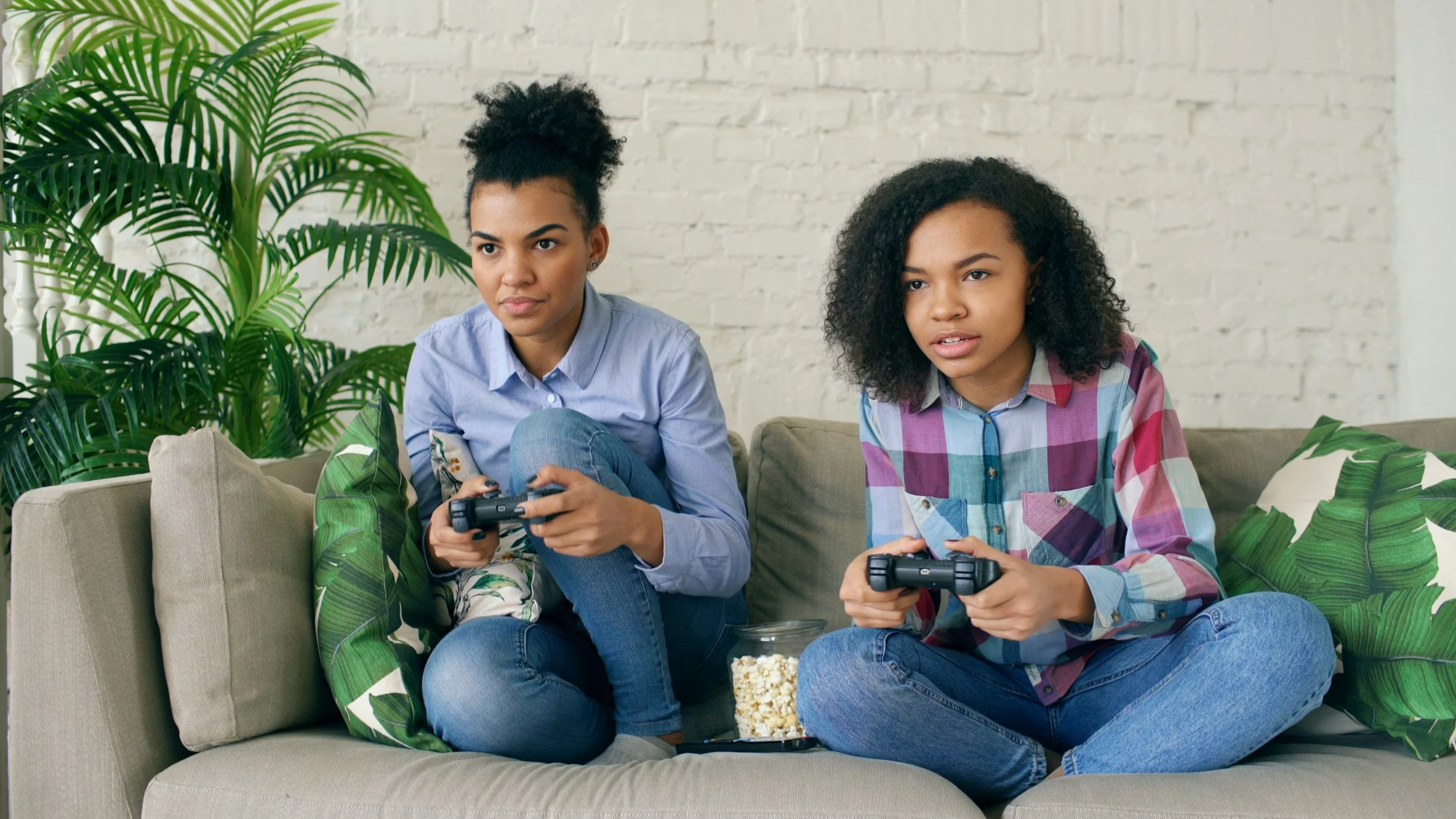 Teens playing video games featured in a blog by Grateful Heart Company called ' When to Start Your Baby Registry as Adoptive Parents.'