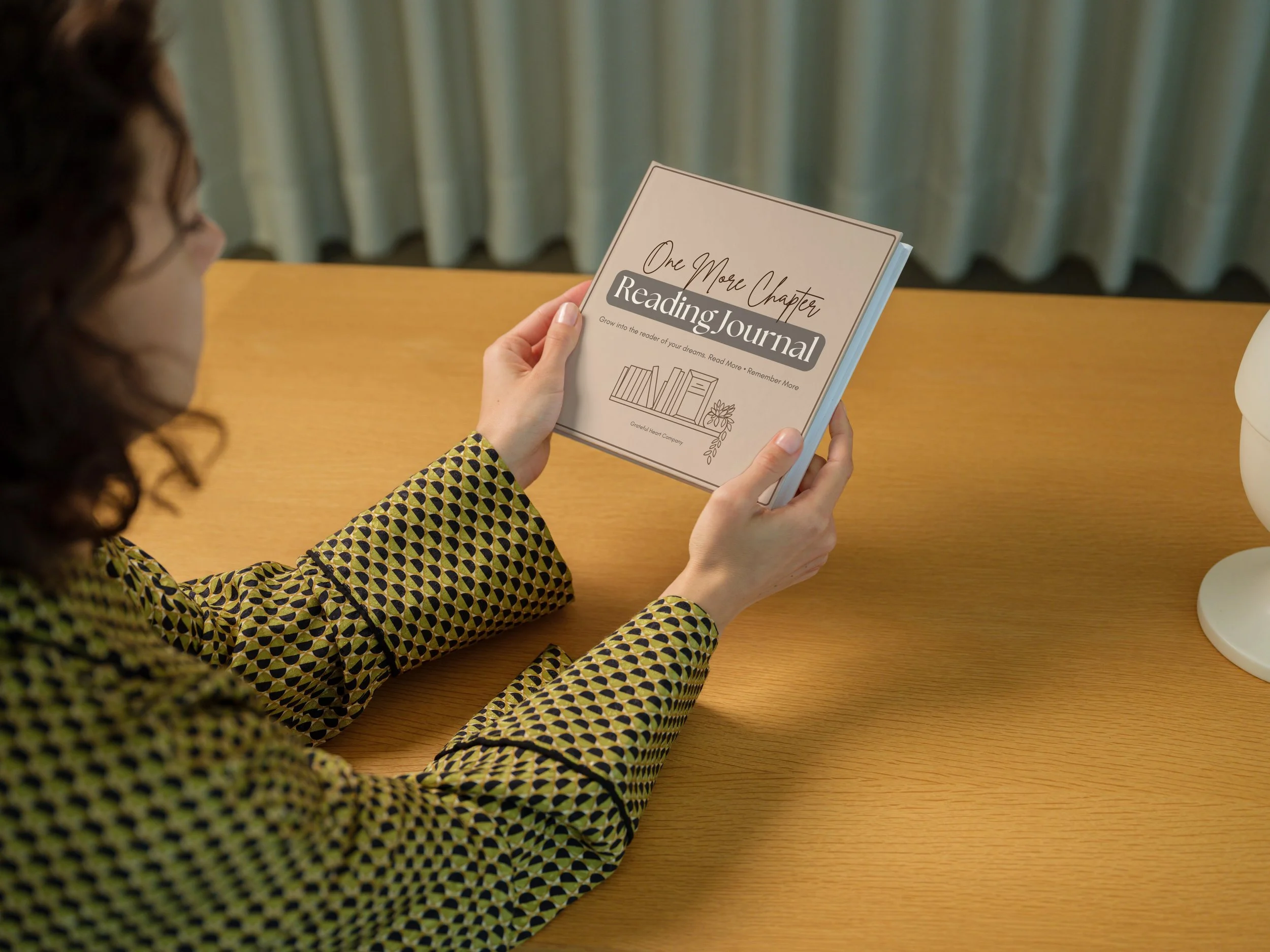 Woman holding Reading Journal from Grateful Heart Company.