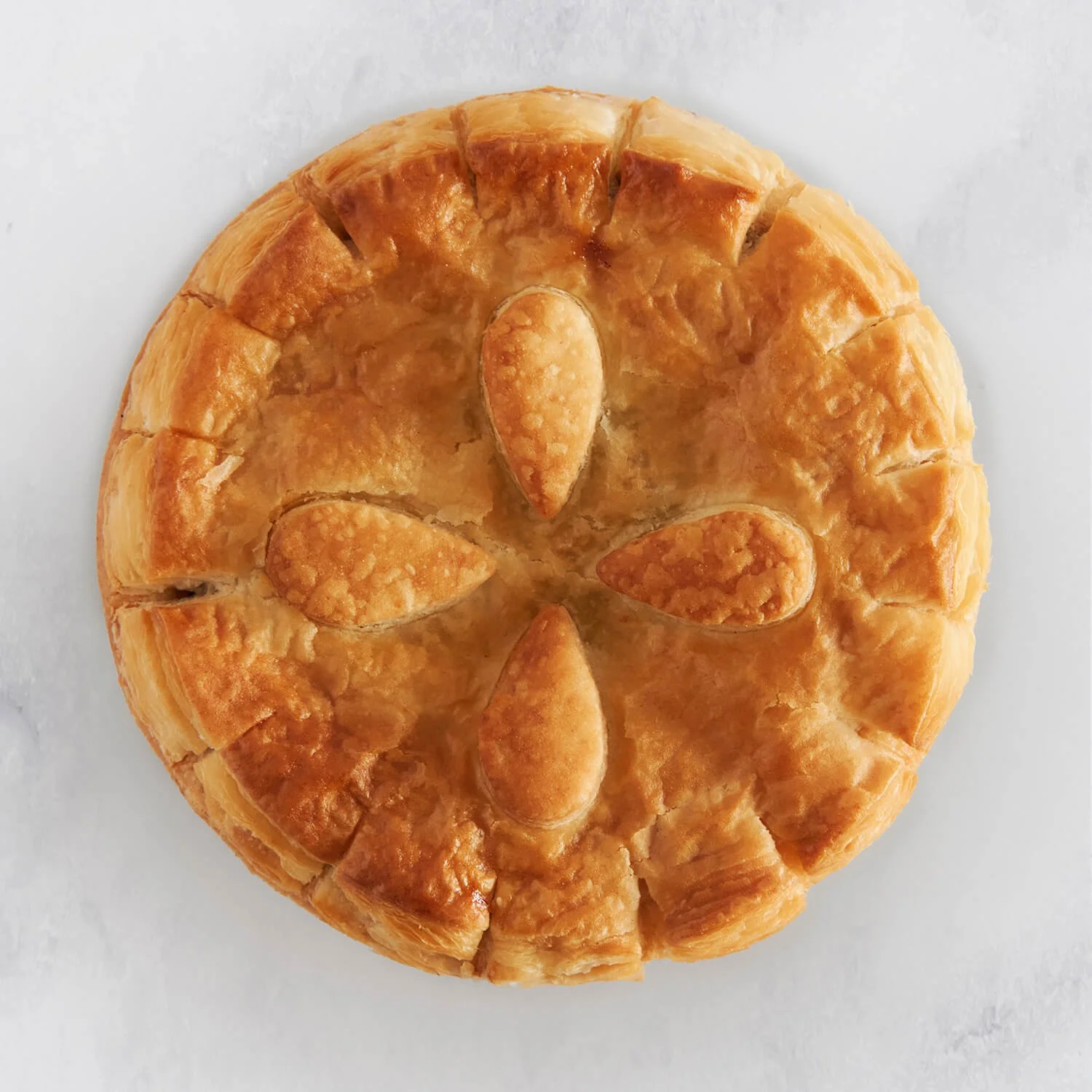 Puff Pastry Chunky Steak Pie with a flaky flower pattern on top