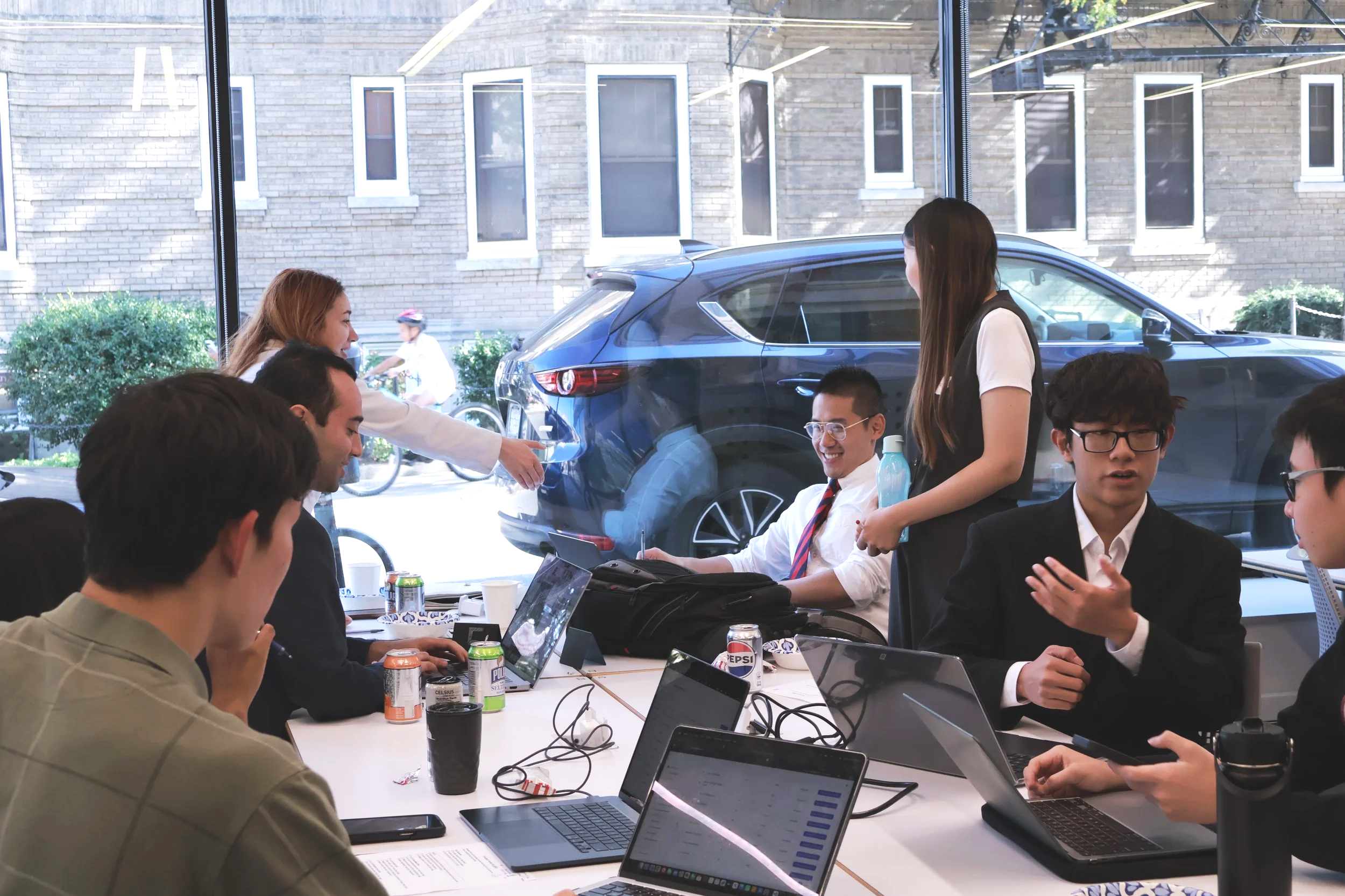Student entrepreneurs engaging in face-to-face team collaboration and real-time market negotiation at the Boston University SimBus business simulation event.