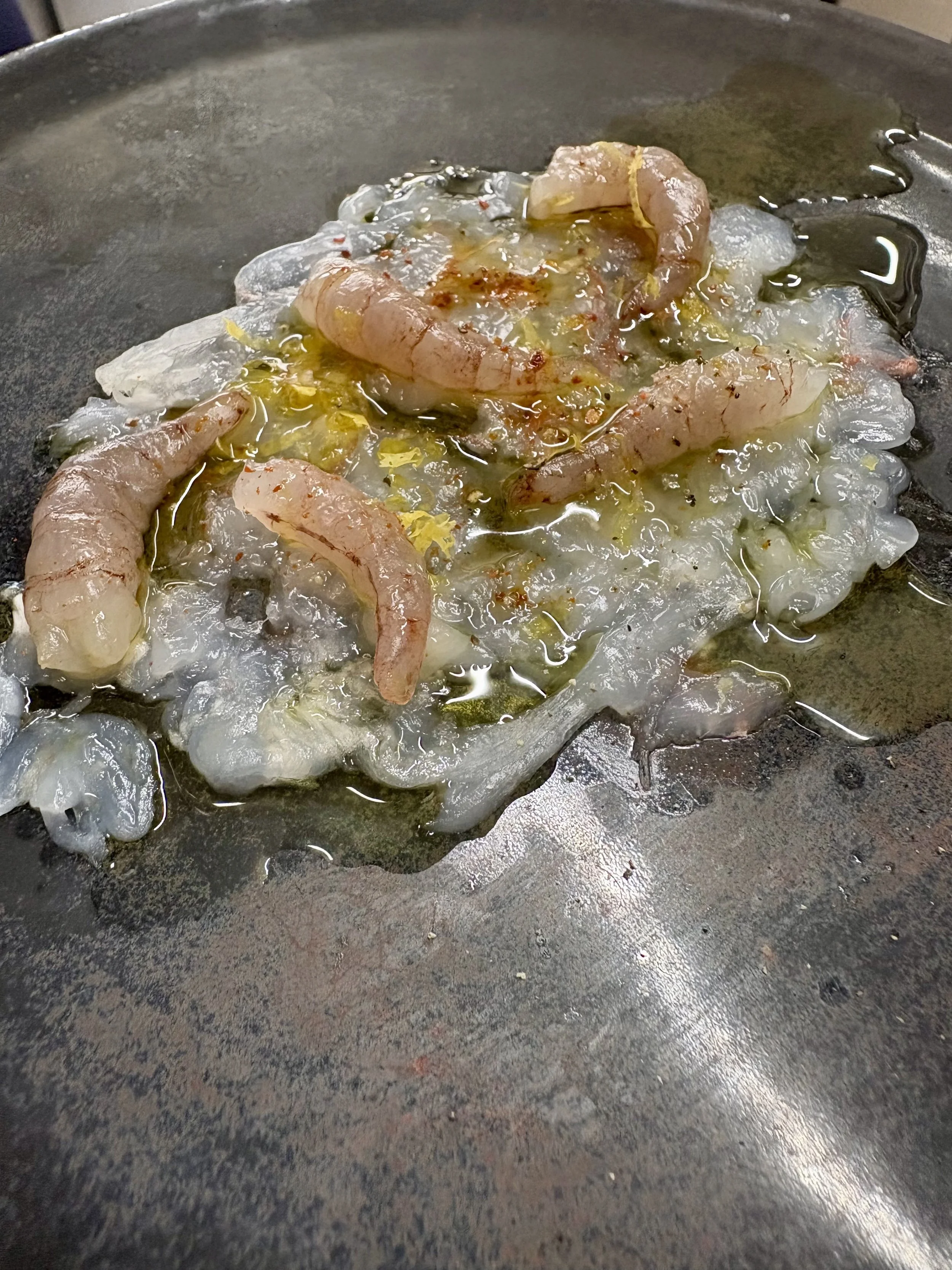 Crevettes en train d'être sautées à la poêle avec de l'ail et des épices.