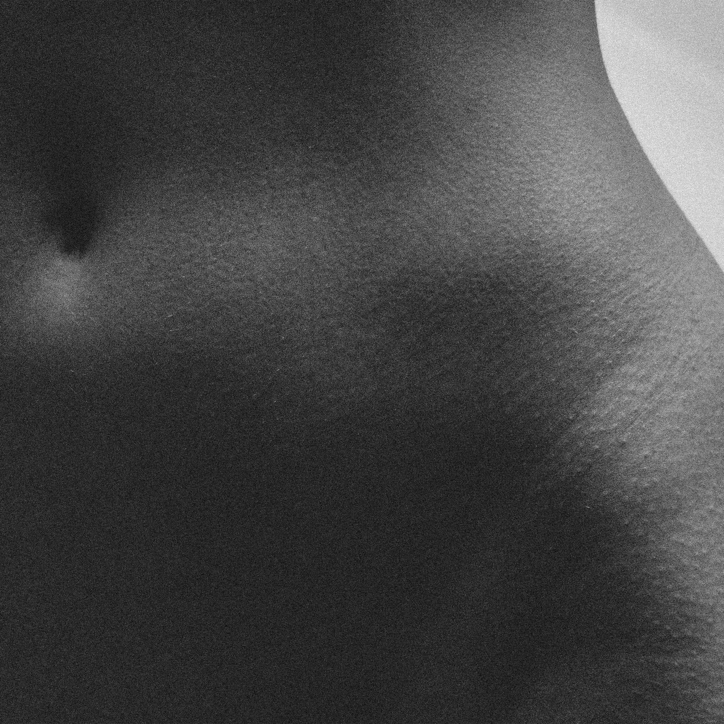 Une photo en noir et blanc montrant une surface texturée, probablement la peau d'une personne ou une surface similaire.