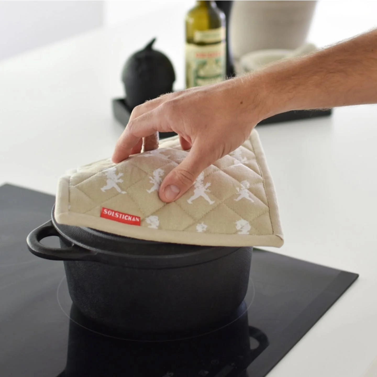 Vadderad Grytlapp i 100% bomull. Repeterande m&ouml;nster med avbildning av den klassiska Solstickepojken ritad av Einar Nerman 1936.