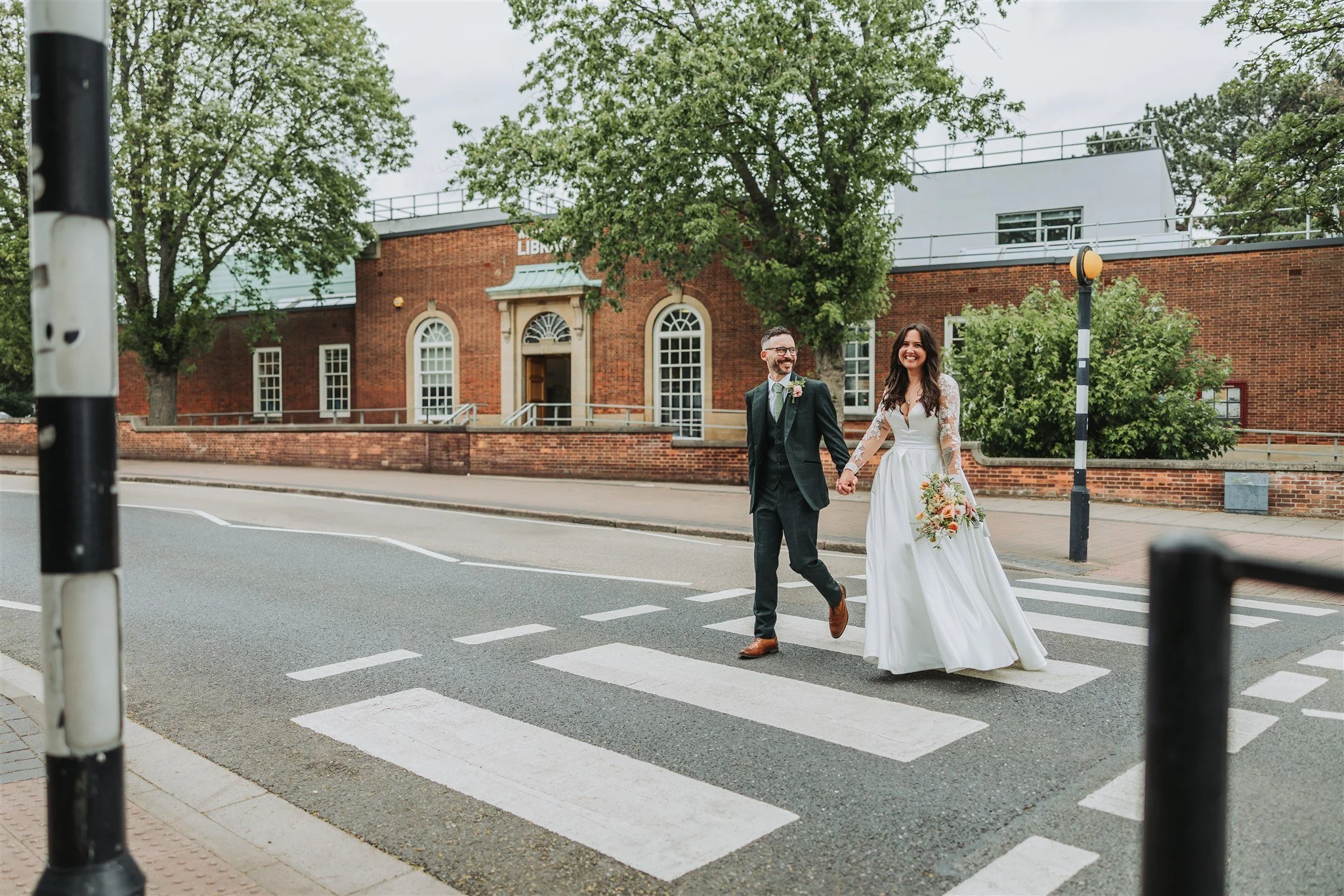 Wedding couple crossing zebra crossing in Nottingham.