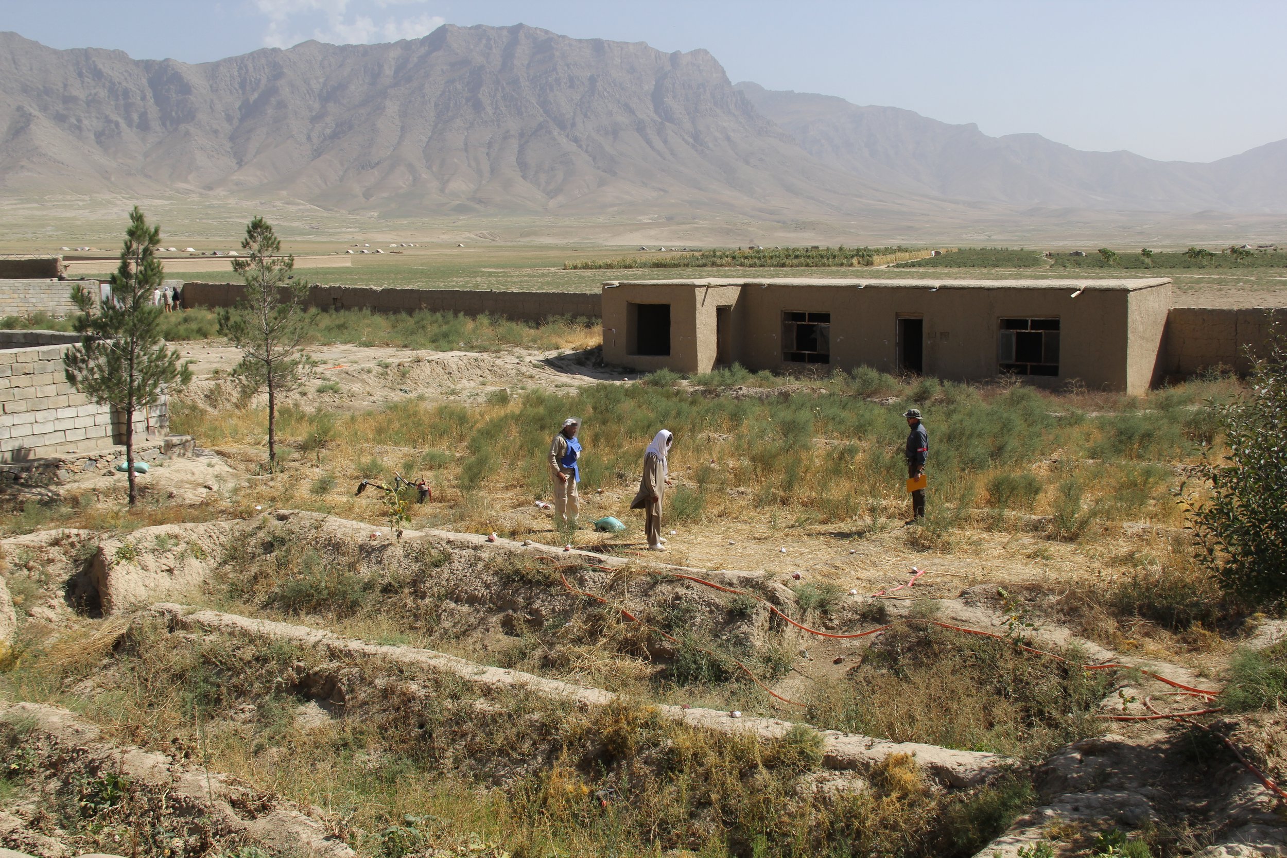  Trainees in a rugged terrain practice operational procedures, highlighting Artios Global's field-based training for real-world mine action scenarios. 