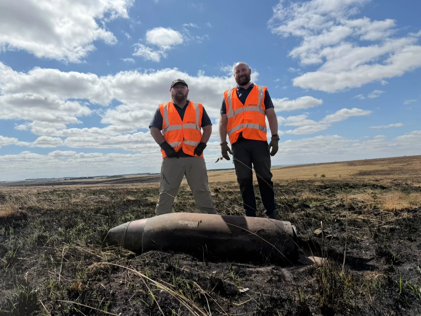 Unexploded bomb discovered on scorched ground during wildfire management operations.