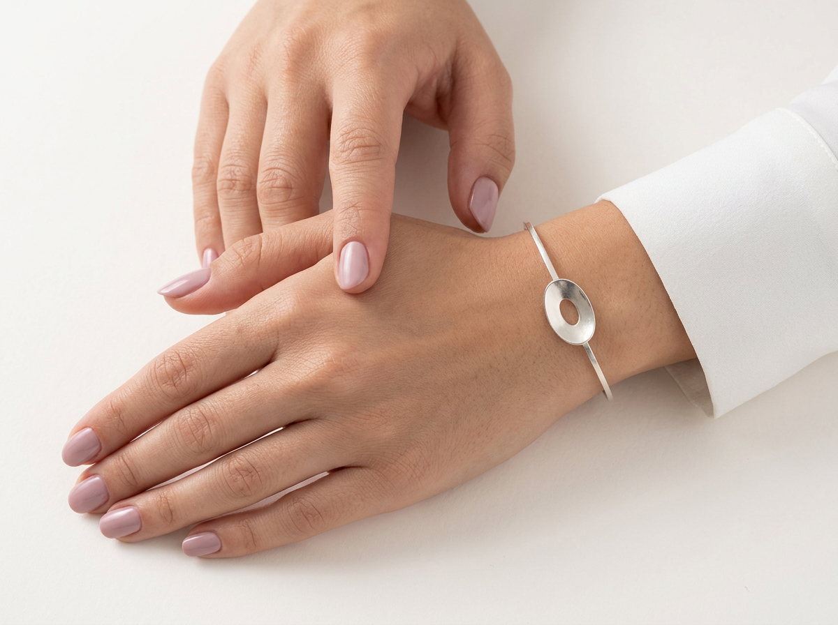 Woman wearing the sterling silver Floating Ovals reflection bangle.