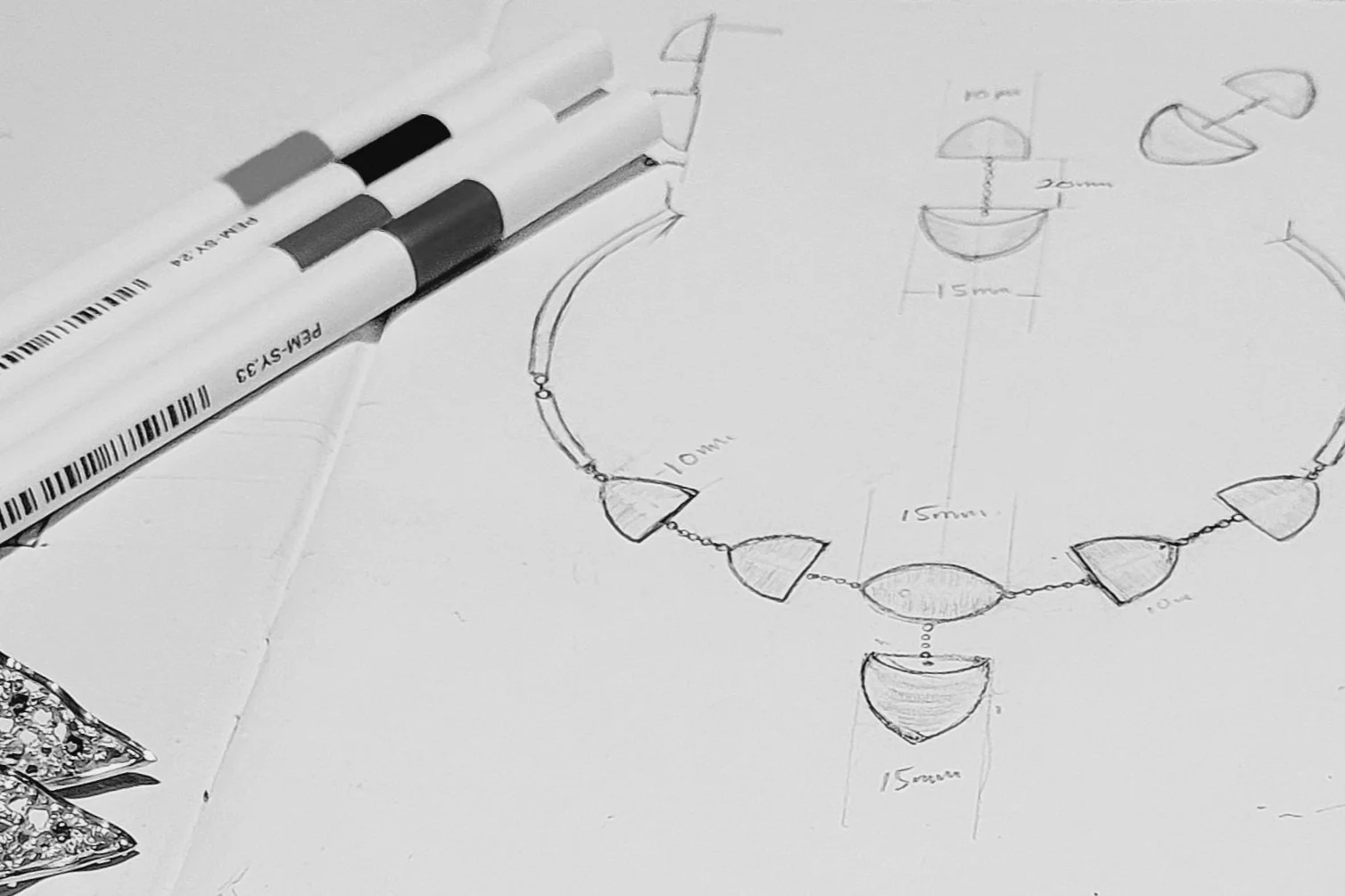 Hand Sketch of a  bespoke necklace with  different pens on the paper.