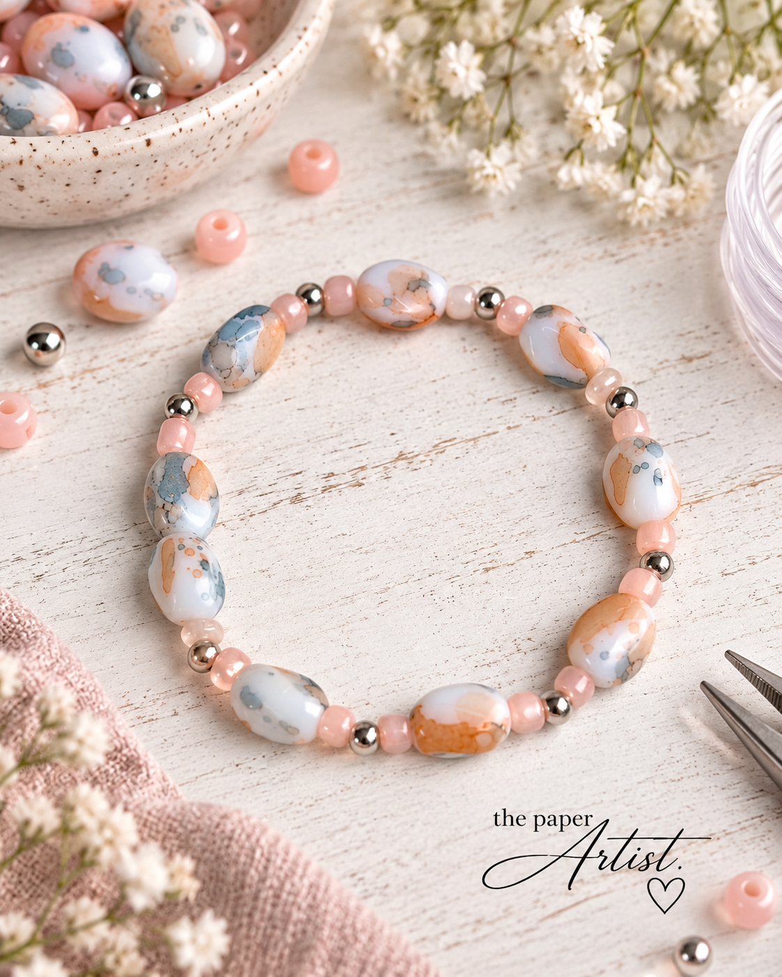 Two handmade stretch beaded bracelets featuring coordinating marbled focal beads, styled with different blue and peach accent bead combinations for a This or That jewelry design comparison.