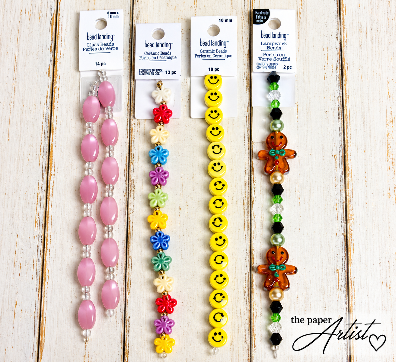 Yellow smiley face beads, colorful ceramic flowers, pink glass beads, and gingerbread lampwork beads.